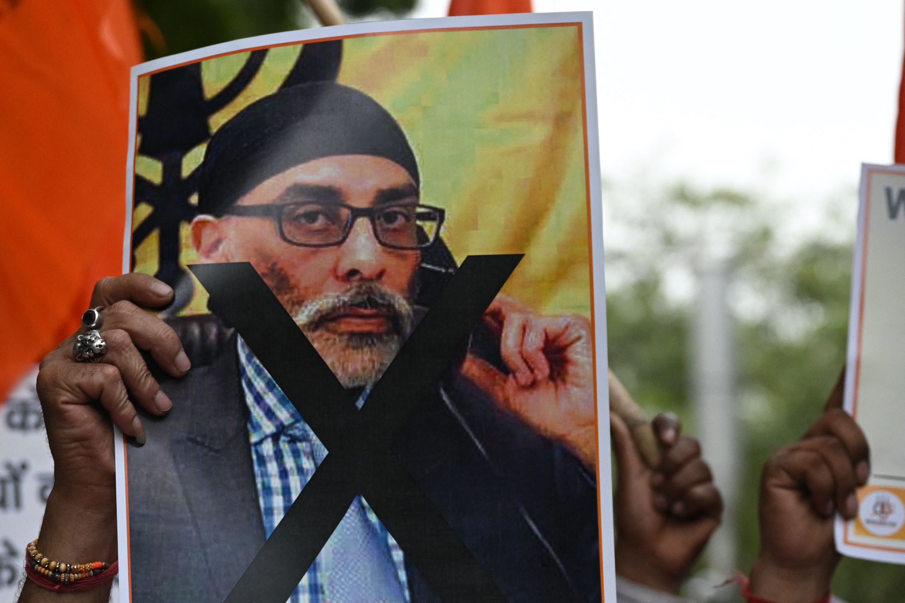 A member of the United Hindu Front organisation holds a banner depicting Gurpatwant Singh Pannun