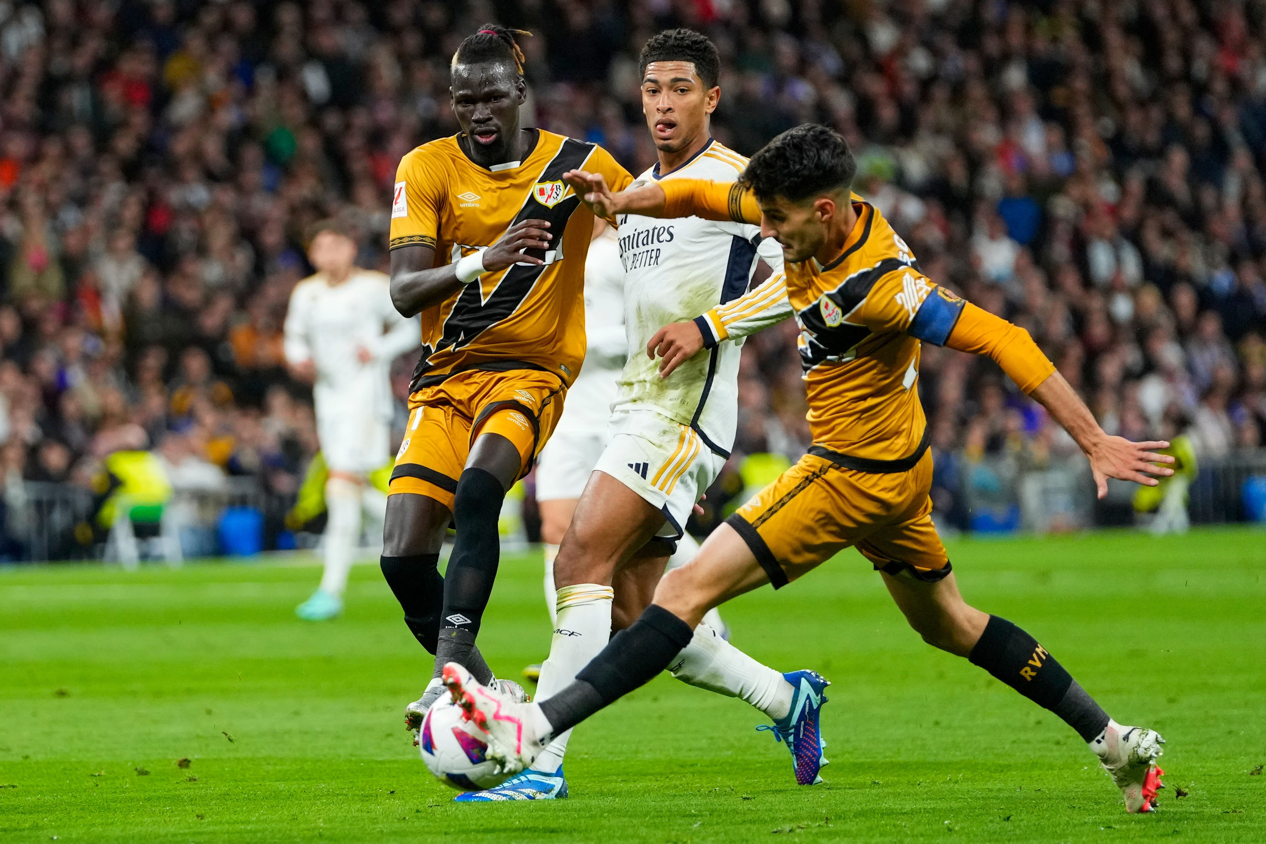 Real Madrid’s Jude Bellingham, duels for the ball with Rayo Vallecano’s Oscar Valentin (left) and Pathe Ciss (Manu Fernandez/AP)