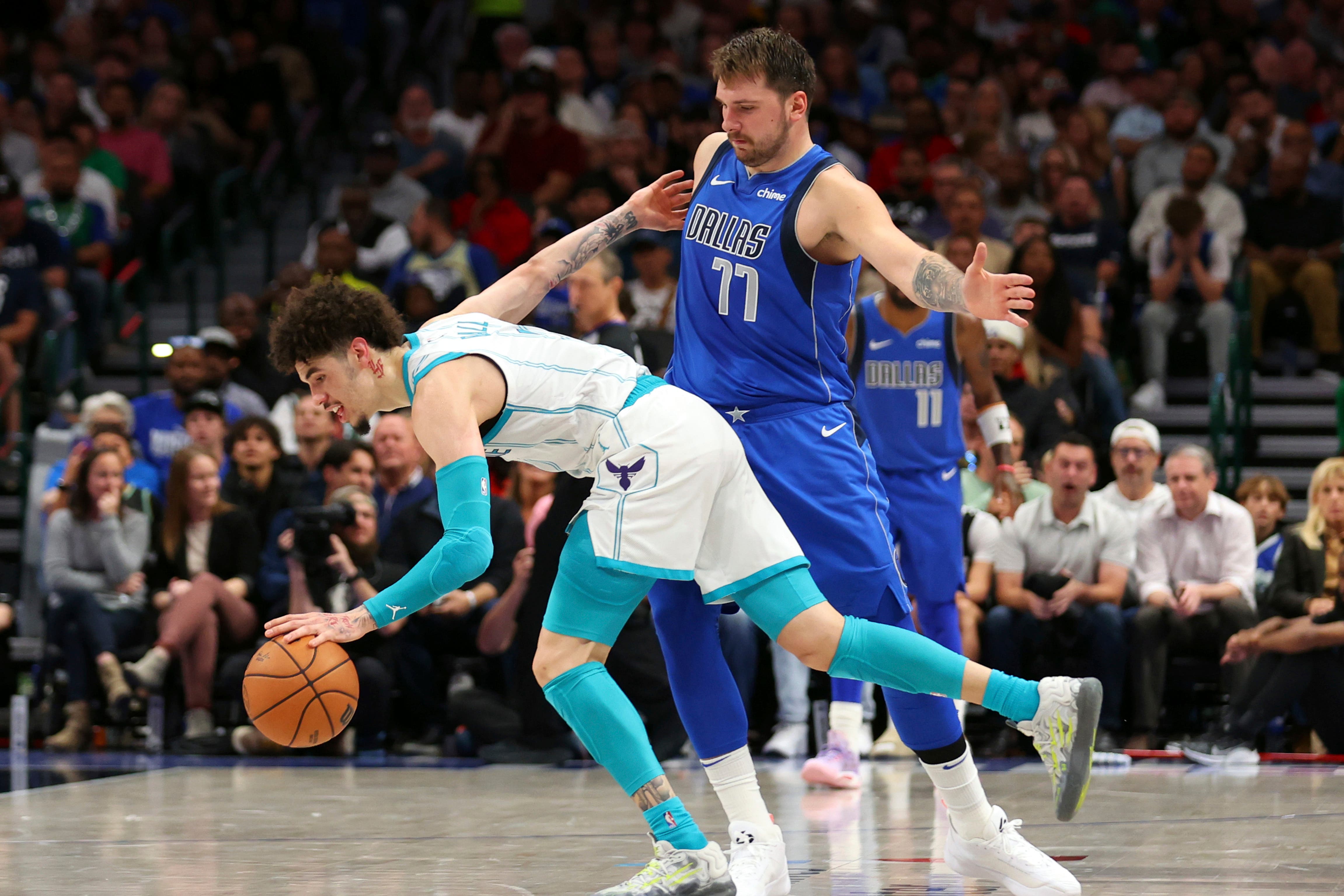 Charlotte Hornets guard LaMelo Ball, left, drives past Dallas Mavericks guard Luka Doncic (Richard W Rodriguez/AP)