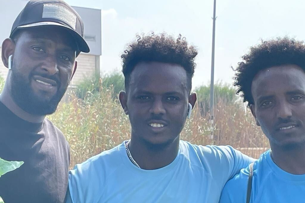 Berhane Negassi, left, with other Eritreans helping with work on the farm