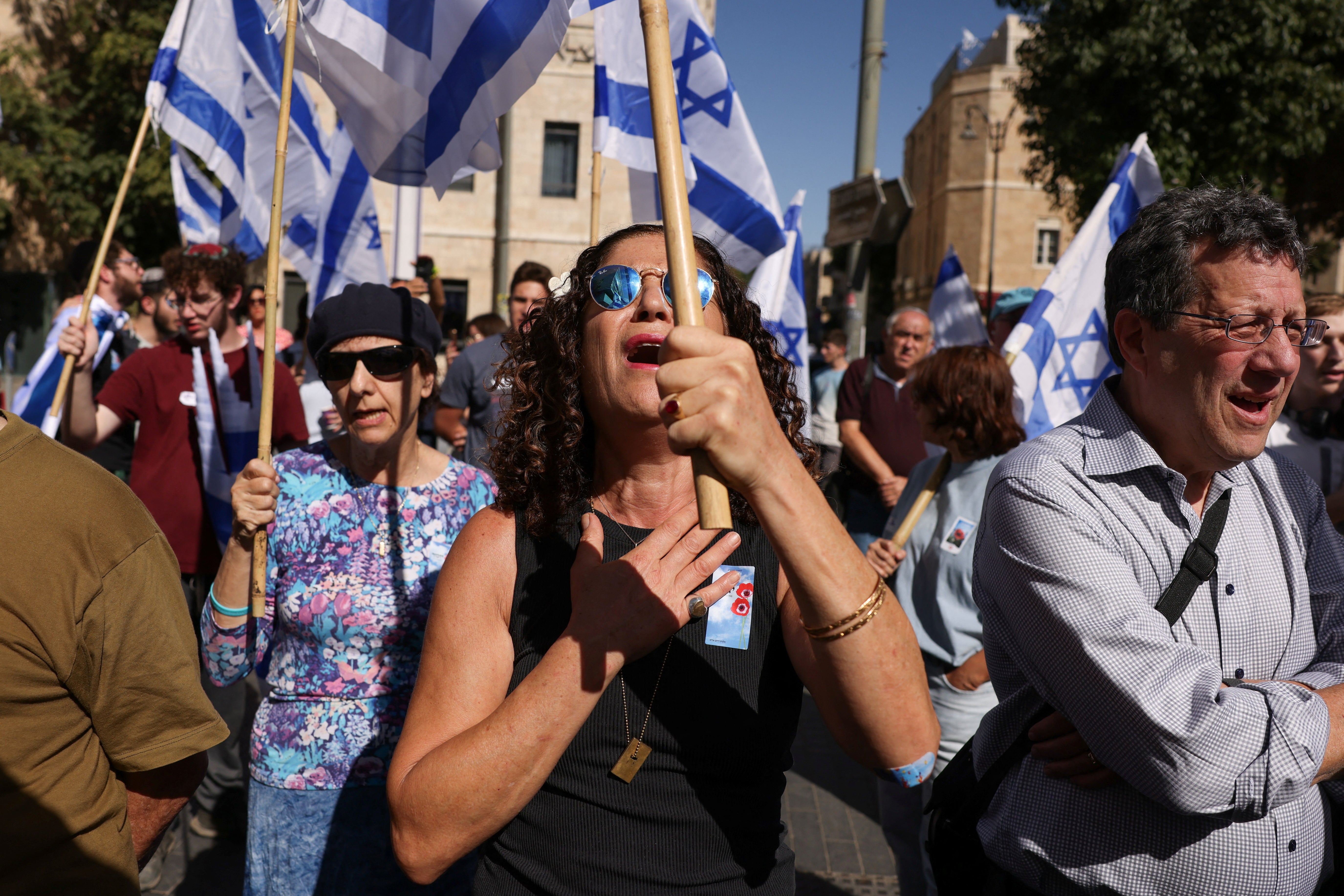 People hold Israeli flags in Jerusalem, marking one-month since Hamas’s attacks which left 1,400 dead