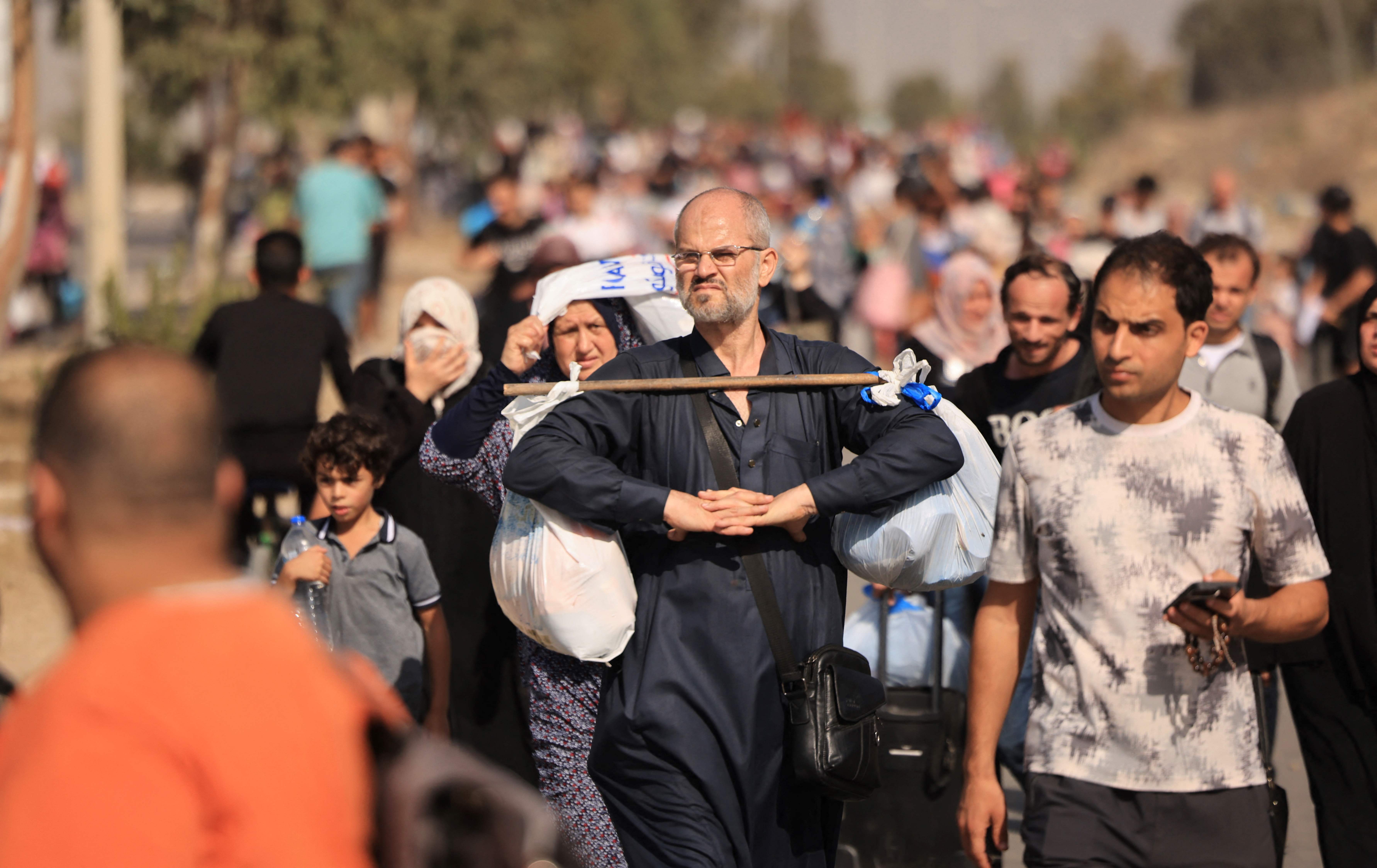 Palestinians families fleeing Gaza City and other parts of northern Gaza towards the southern areas, walk along a highway on November 9, 2023