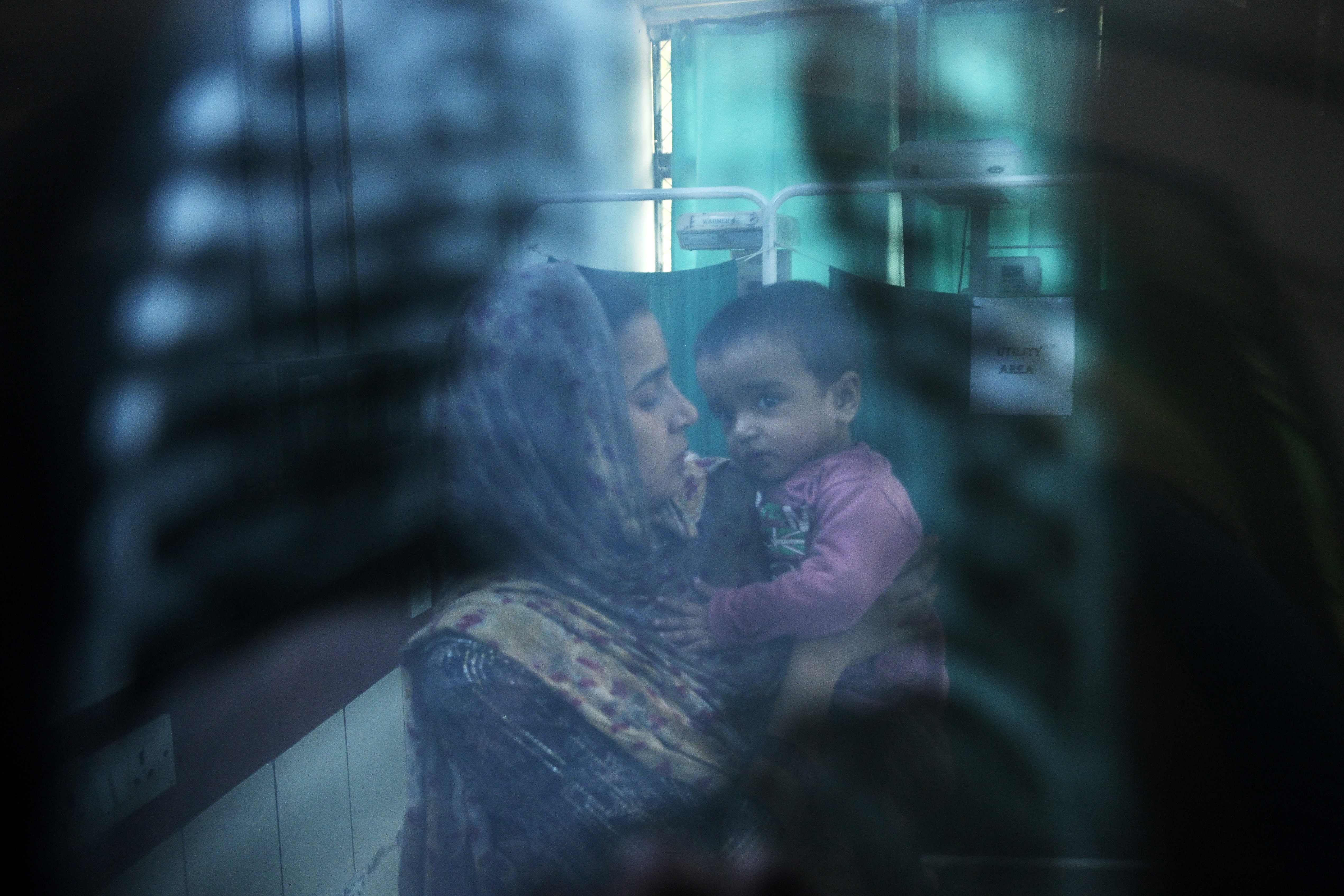 In this picture taken on 7 November 2023, a doctor (not pictured) examines the X-ray of child with breathing difficulties at the emergency ward of the government-run Chacha Nehru Bal Chikitsalaya children hospital in New Delhi