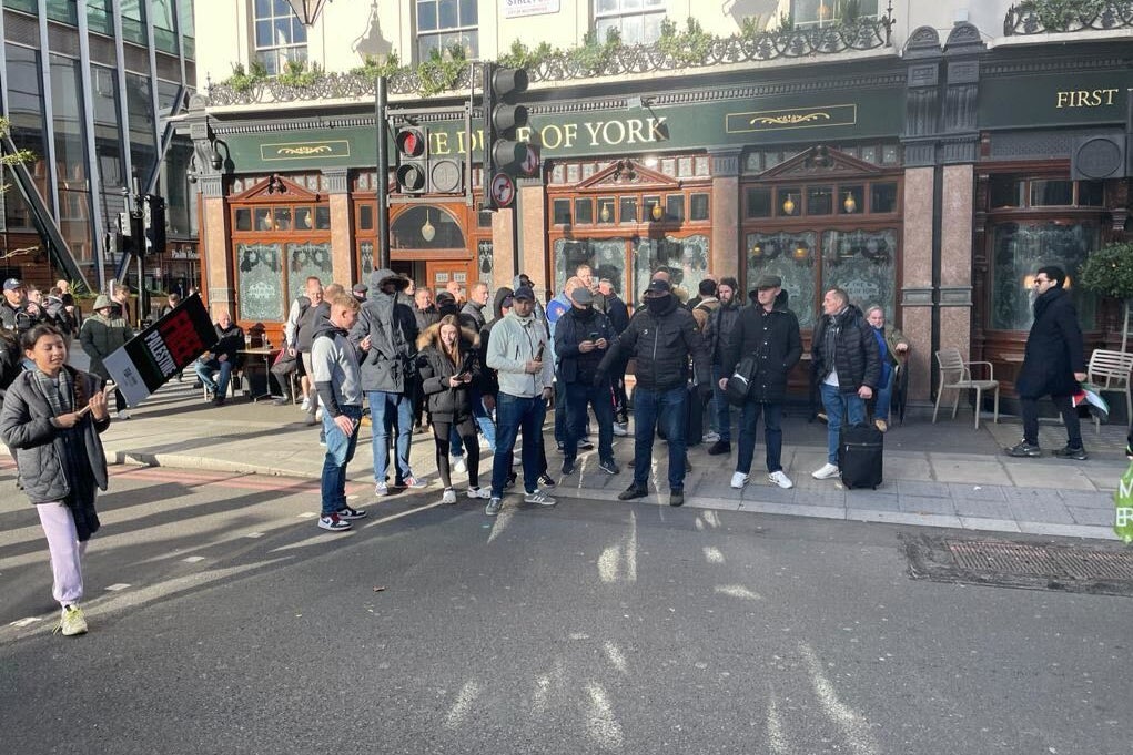 A young pro-Palestinian demonstrator is yelled at outside the Duke of York pub near Victoria station