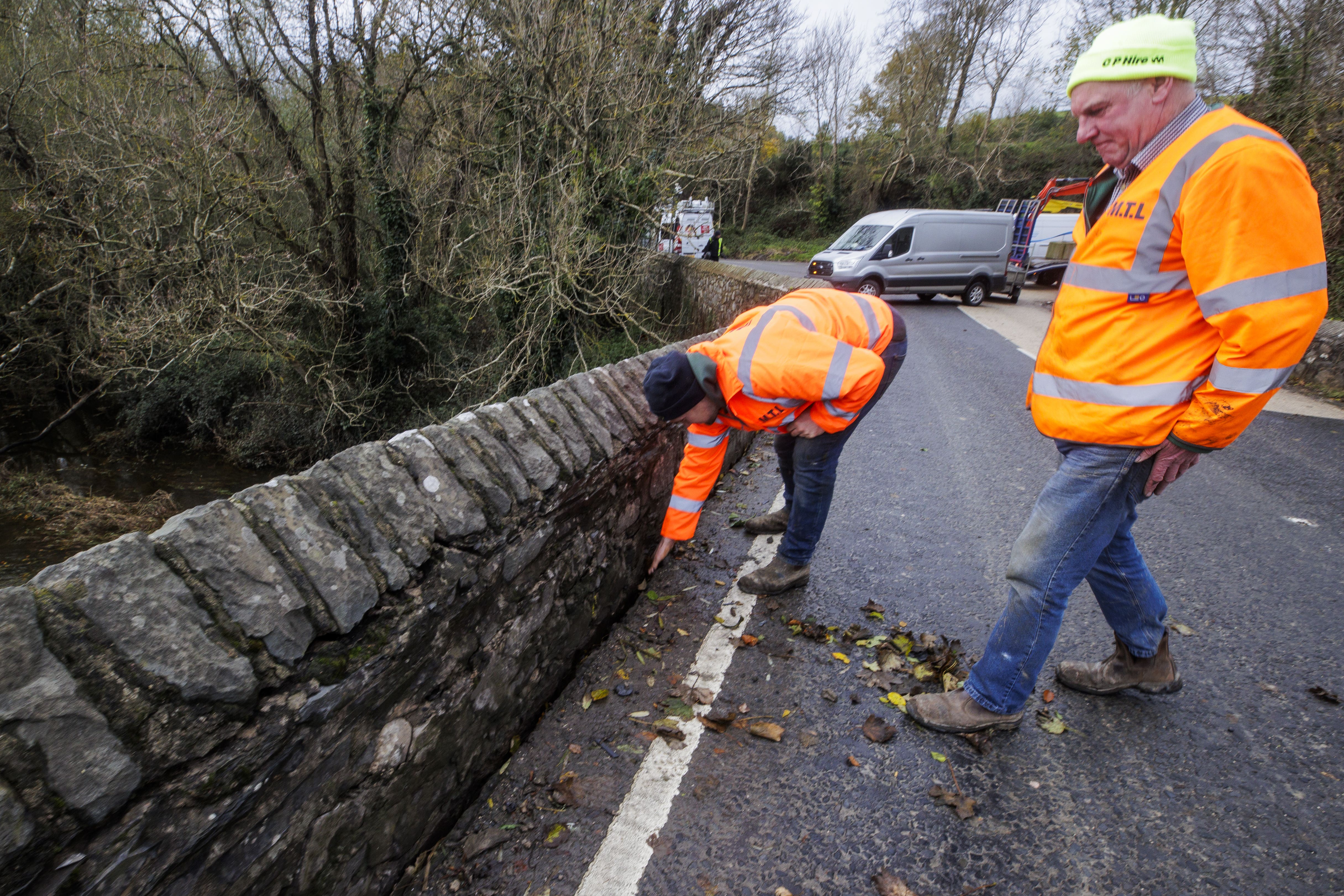 Workers clearing leaves from a section of the Quoile bridge after flooding (Liam McBurney/PA)