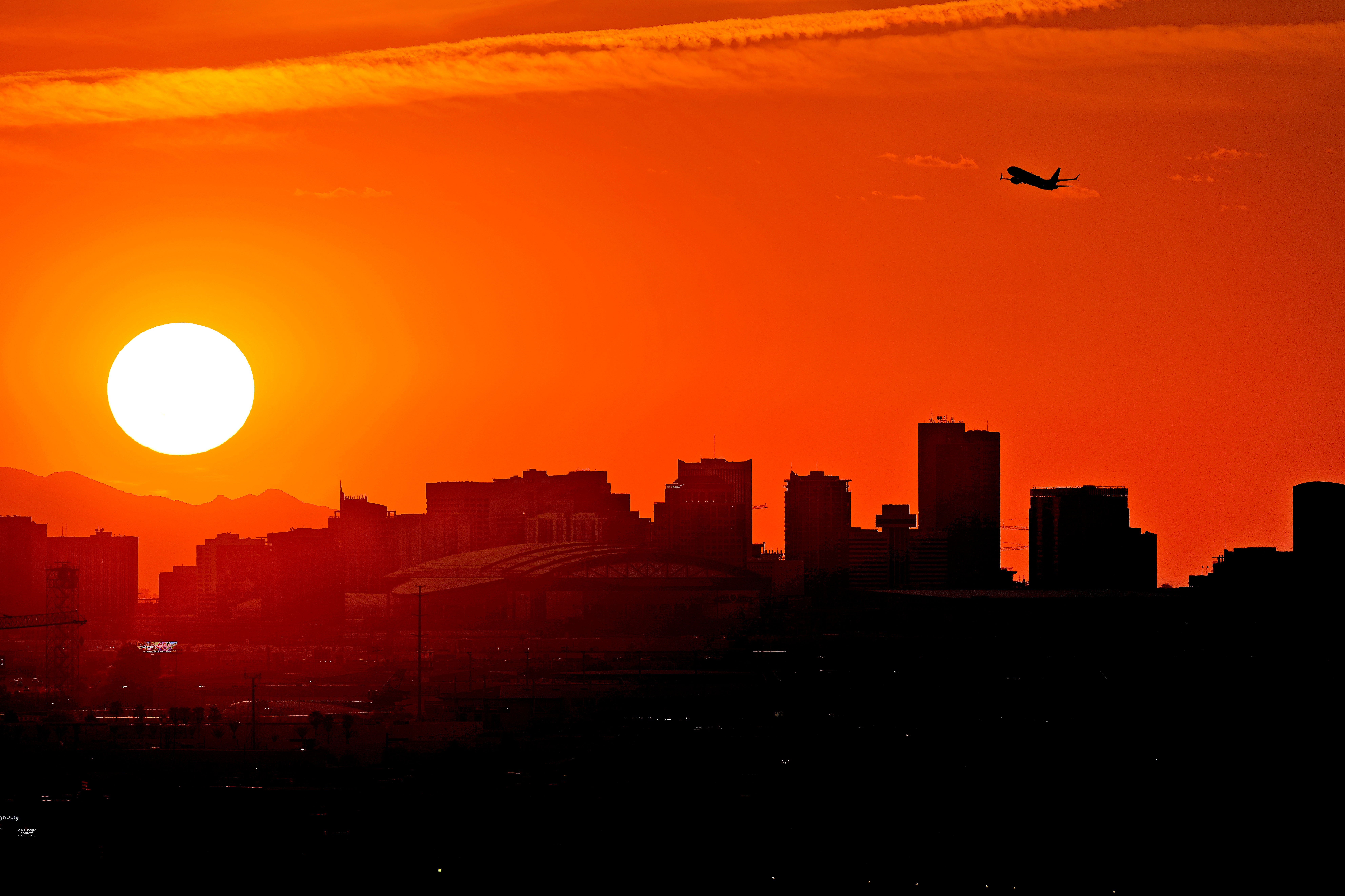 A jet takes flight as the sun sets over Phoenix on July 12, 2023. Arizona’s Maricopa County, the hottest metropolitan area in the U.S. and home to Phoenix, set a record on Oct. 19, 2023, for annual heat-associated deaths