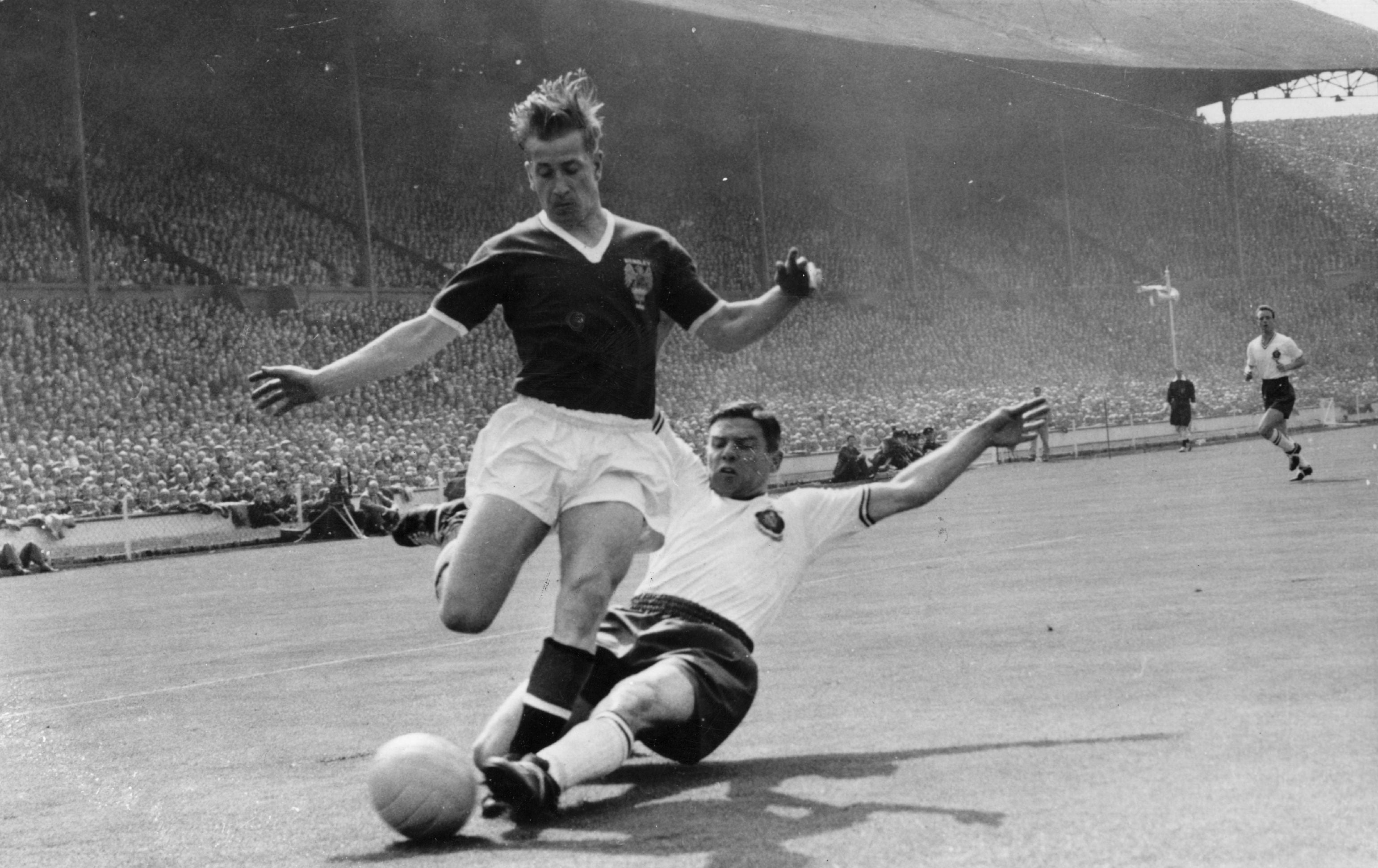 Manchester United’s Bobby Charlton, being slide-tackled by Bolton Wanderers’ Tommy Banks during the 1958 FA Cup final (Keystone/Getty Images)