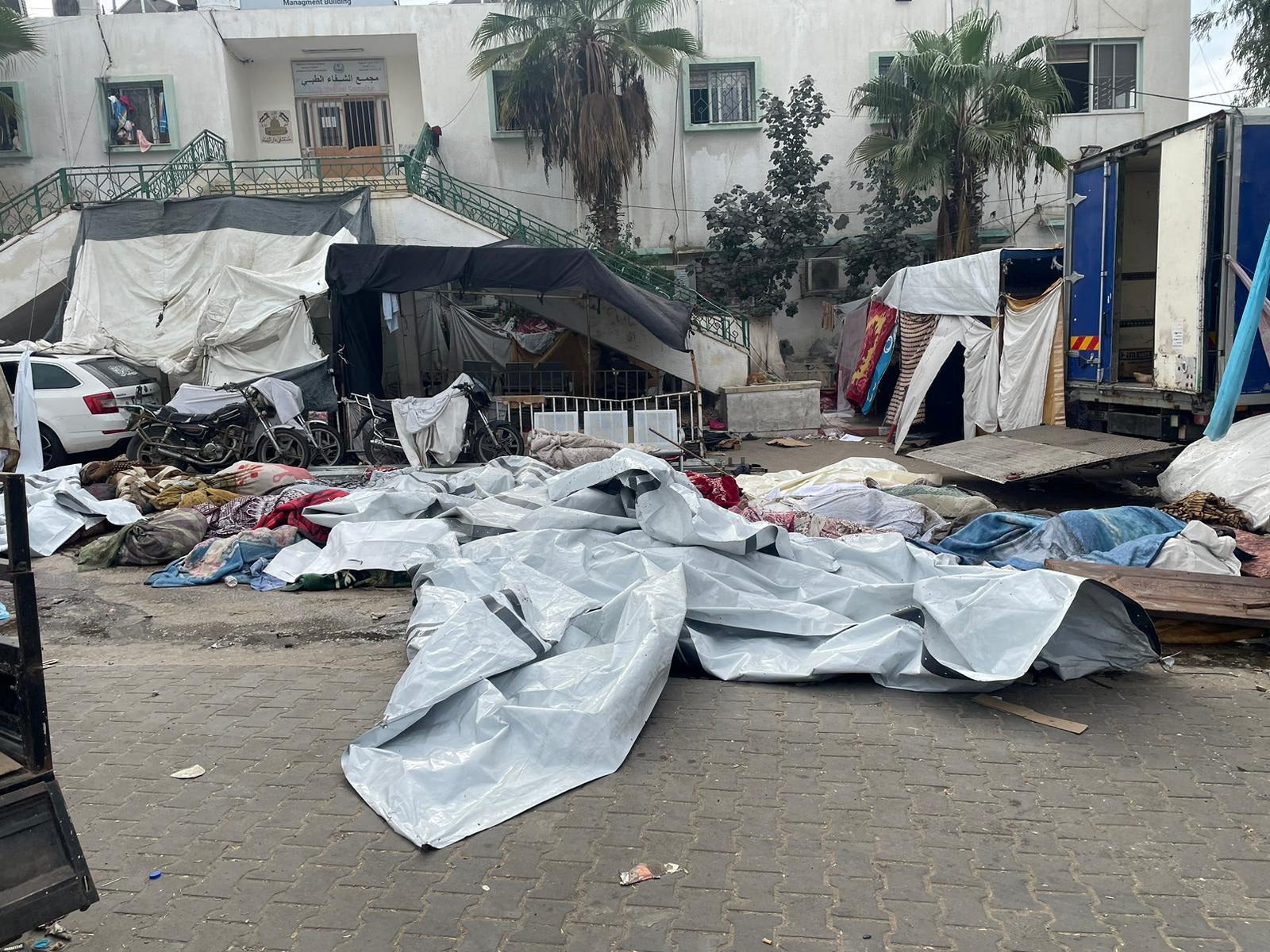 Bodies of Palestinians killed in Israeli strikes lie on the ground at the yard of Al Shifa hospital