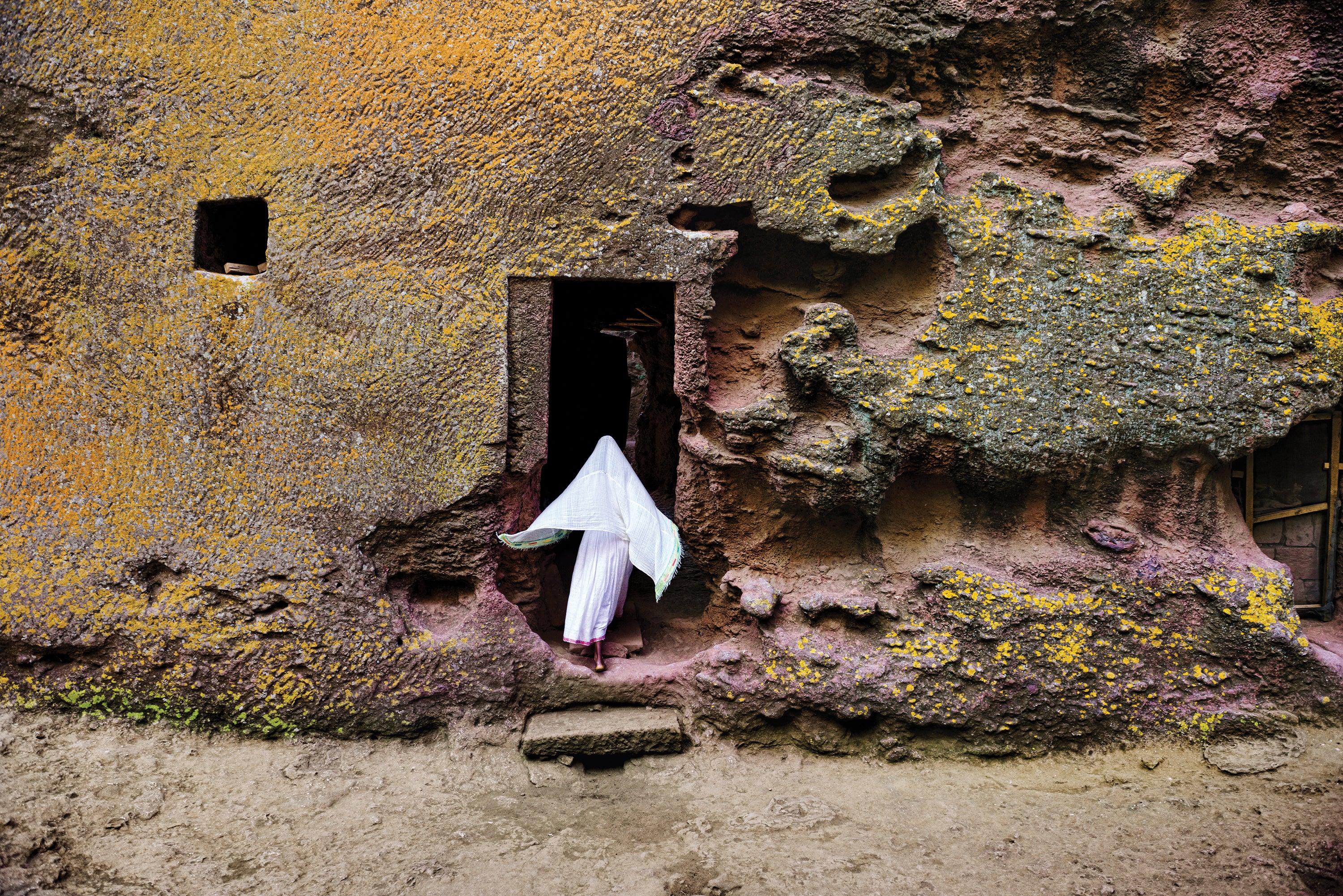 A woman enters a medieval church that is carved into solid rock in Lalibela, Ethiopia. Lalibela is famous for its monolithic rock-cut churches, which date from the seventh to 13th centuries, and were declared a Unesco World Heritage Site in 1978.