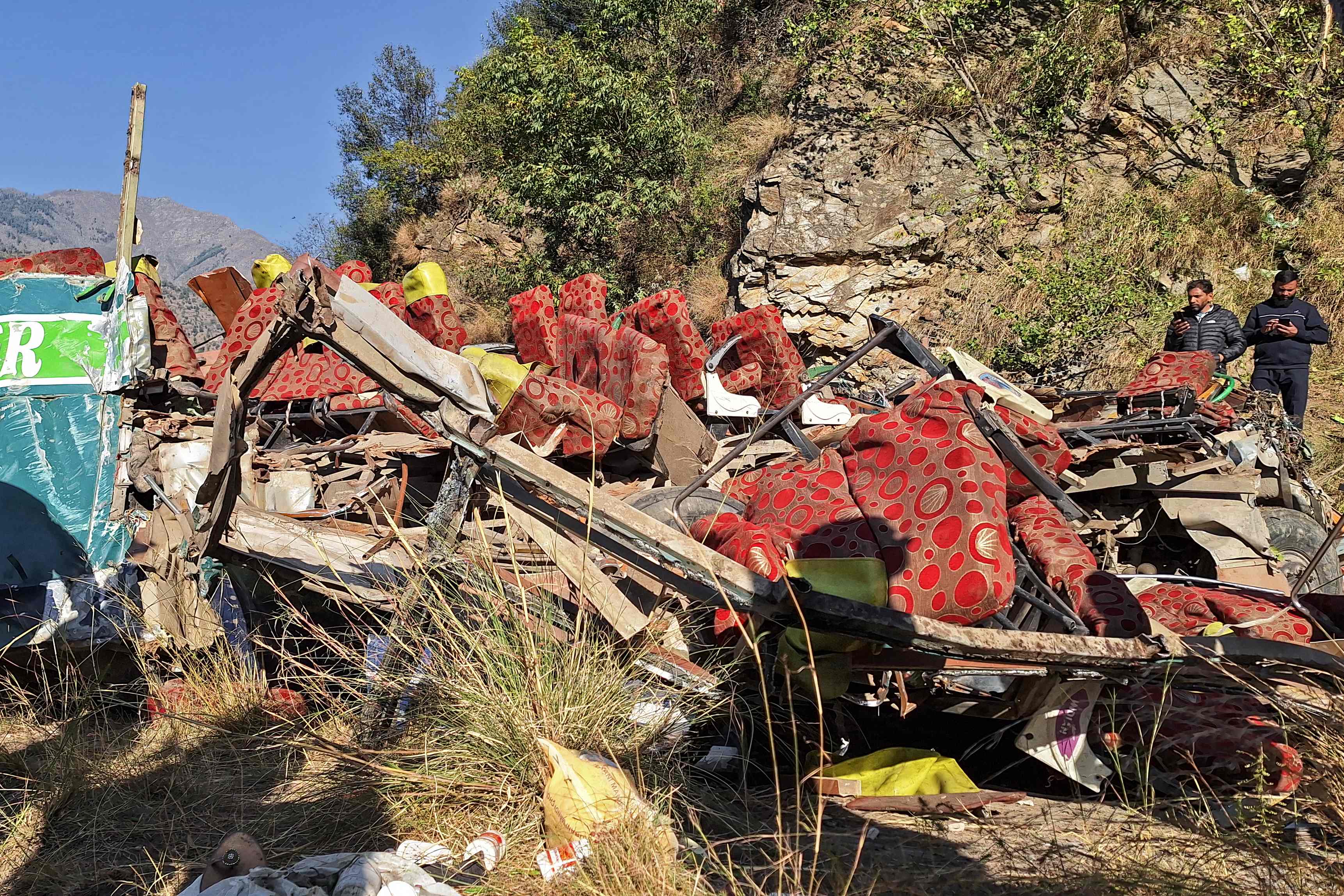 Men gather near the wrecked bus, subject to an accident on a remote mountain road in the Doda area, about 200km (124 miles) southeast of the Srinagar on 15 November 2023