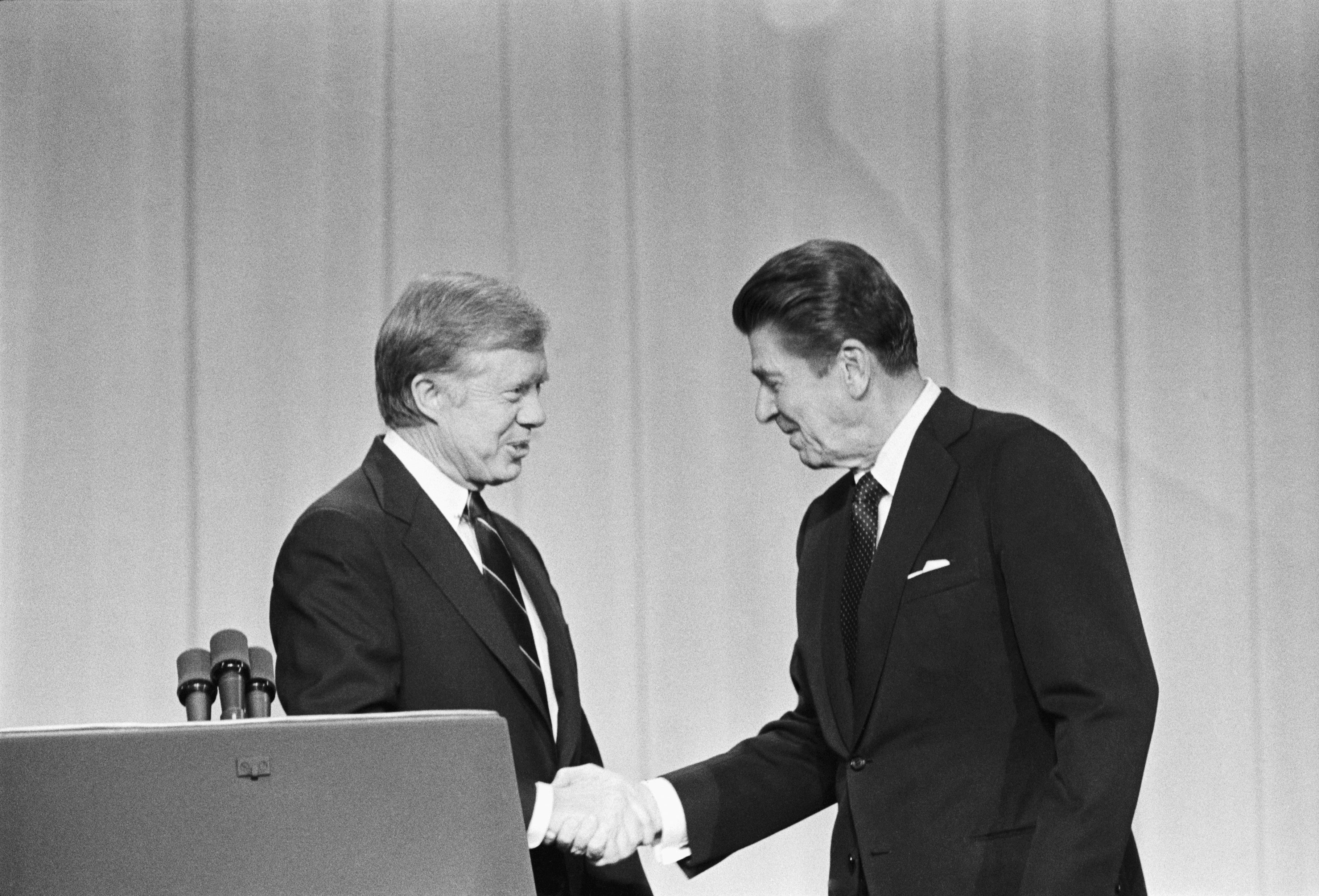 Carter and his Republican challenger, Ronald Reagan, shake hands as they greet one another before their debate on the stage of the Music Hall in Cleveland in 1980