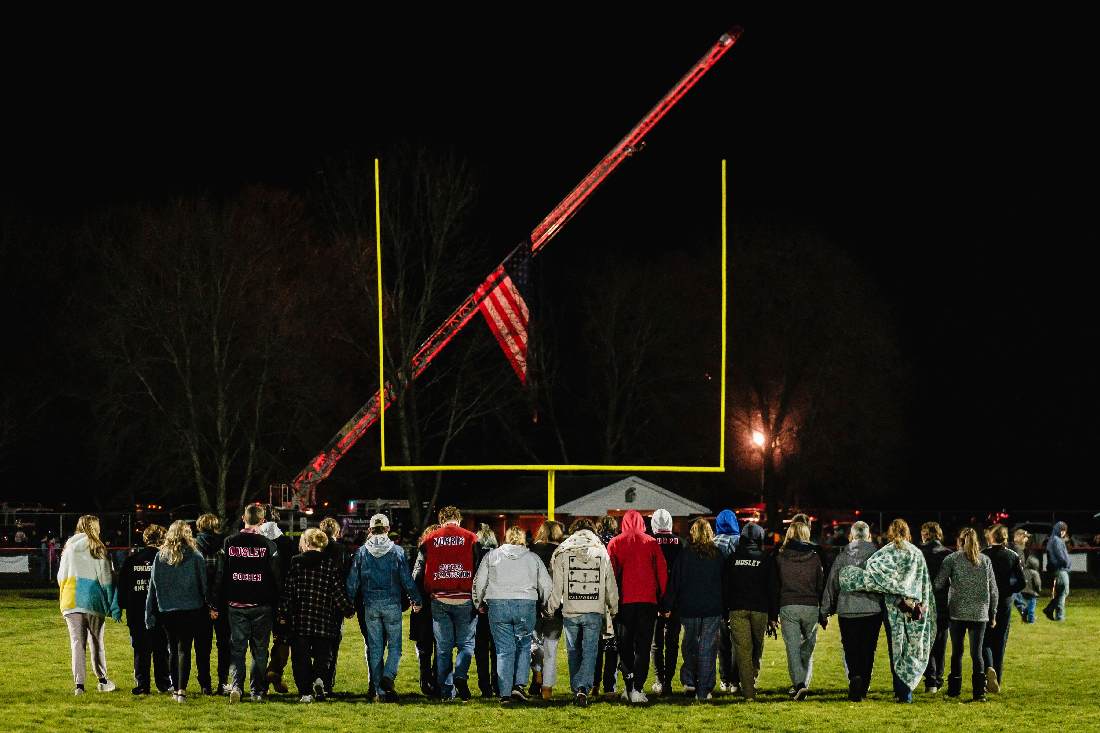 Students walk on the football field during a community prayer vigil, Tuesday, Nov. 14, 2023, at the Tuscarawas Valley Schools football stadium in Zoarville, Ohio.