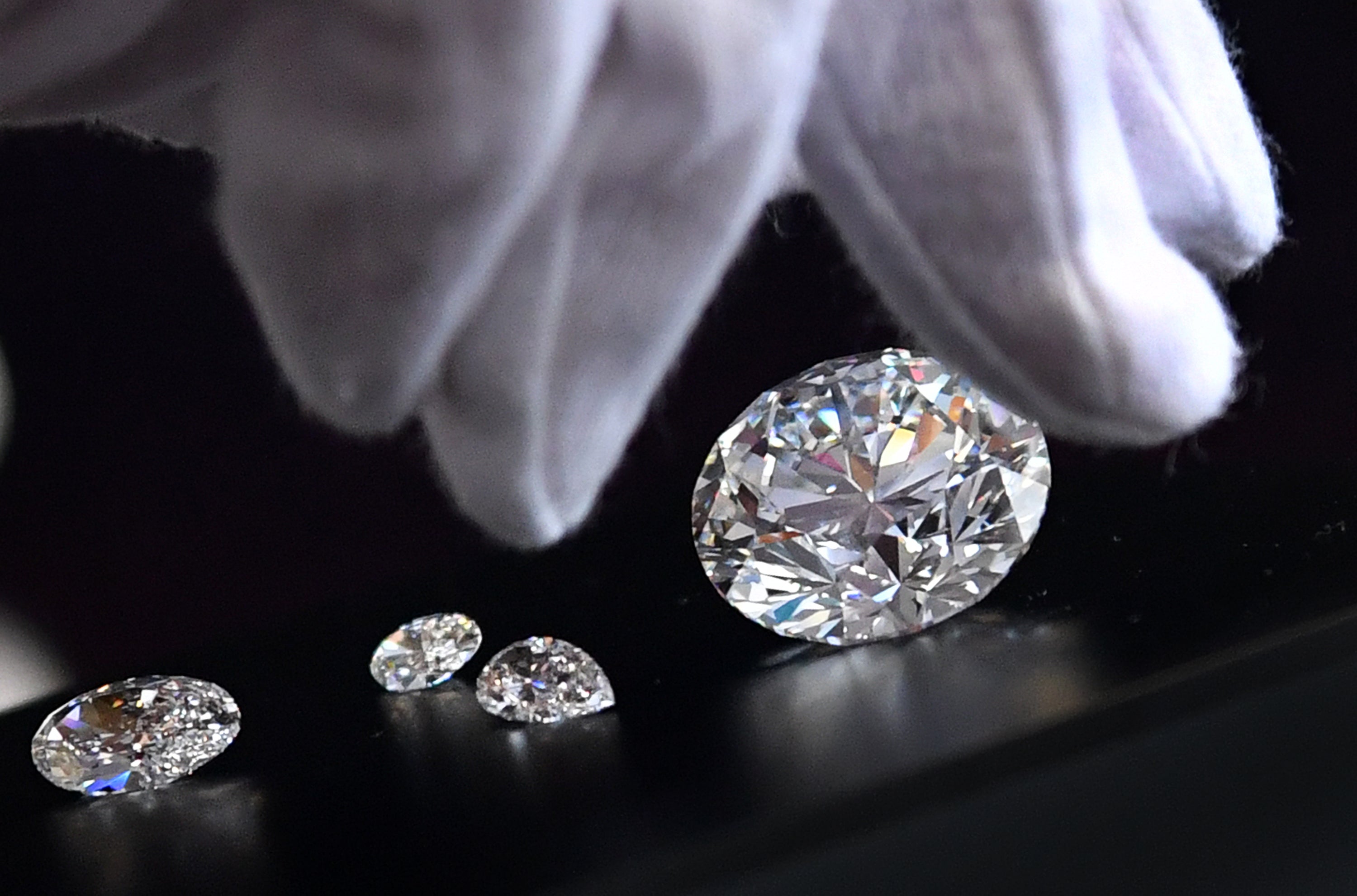 An employee shows the main 51.38-carat round-cut diamond, the Dynasty, among other gems from Russian diamond miner Alrosas Dynasty polished diamonds collection in Moscow