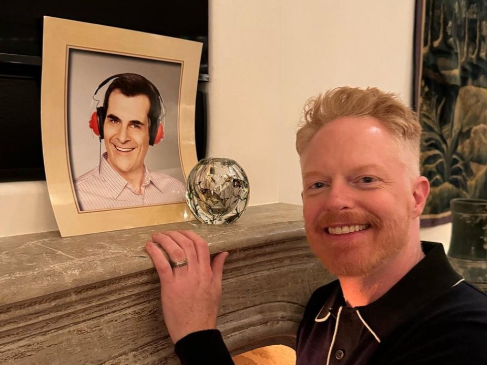 Jesse Tyler Ferguson posing with Ty Burrell’s photo