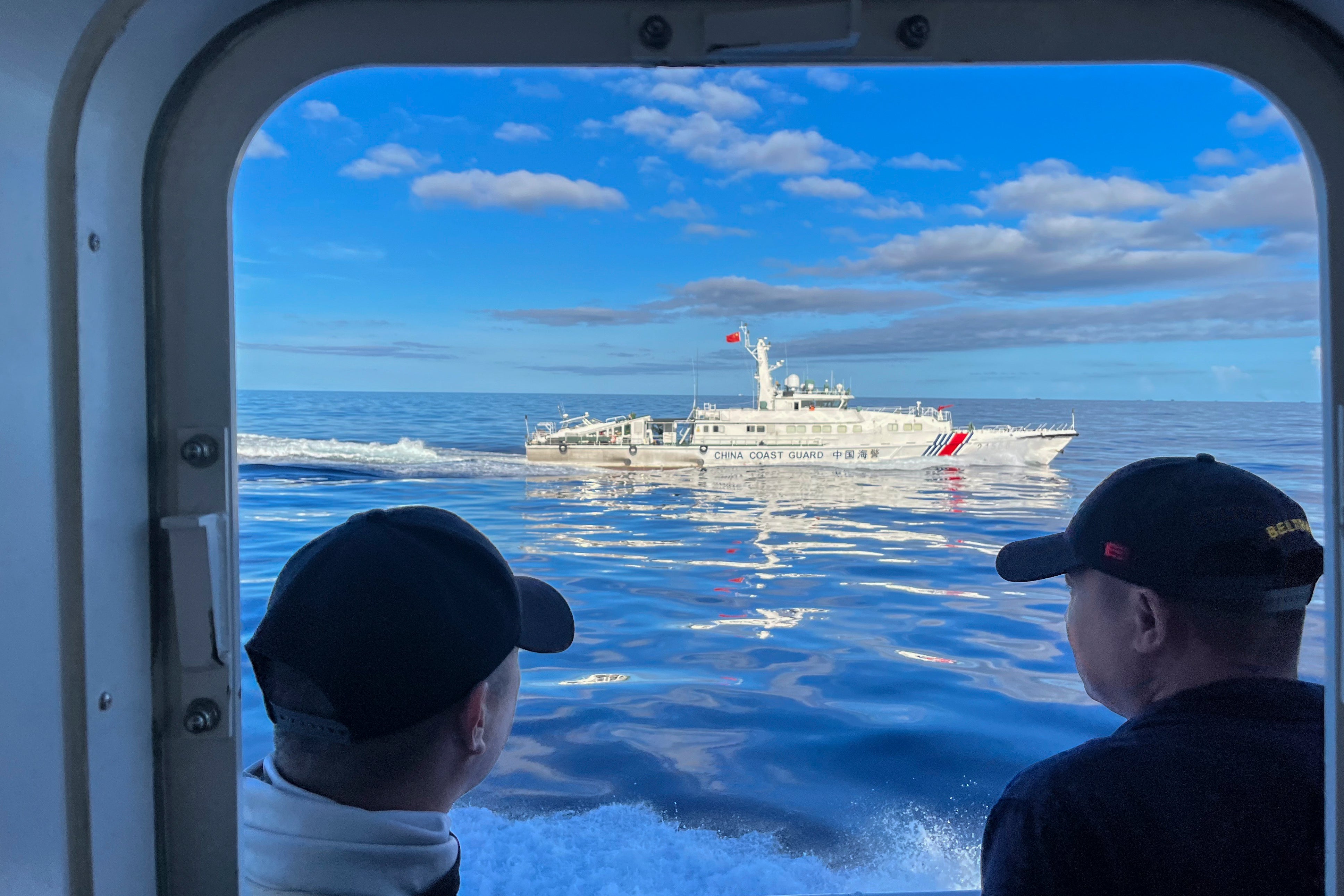 A Chinese coastguard vessel maneuvers beside the Philippine coast guard ship BRP Cabra as they approach Second Thomas Shoal