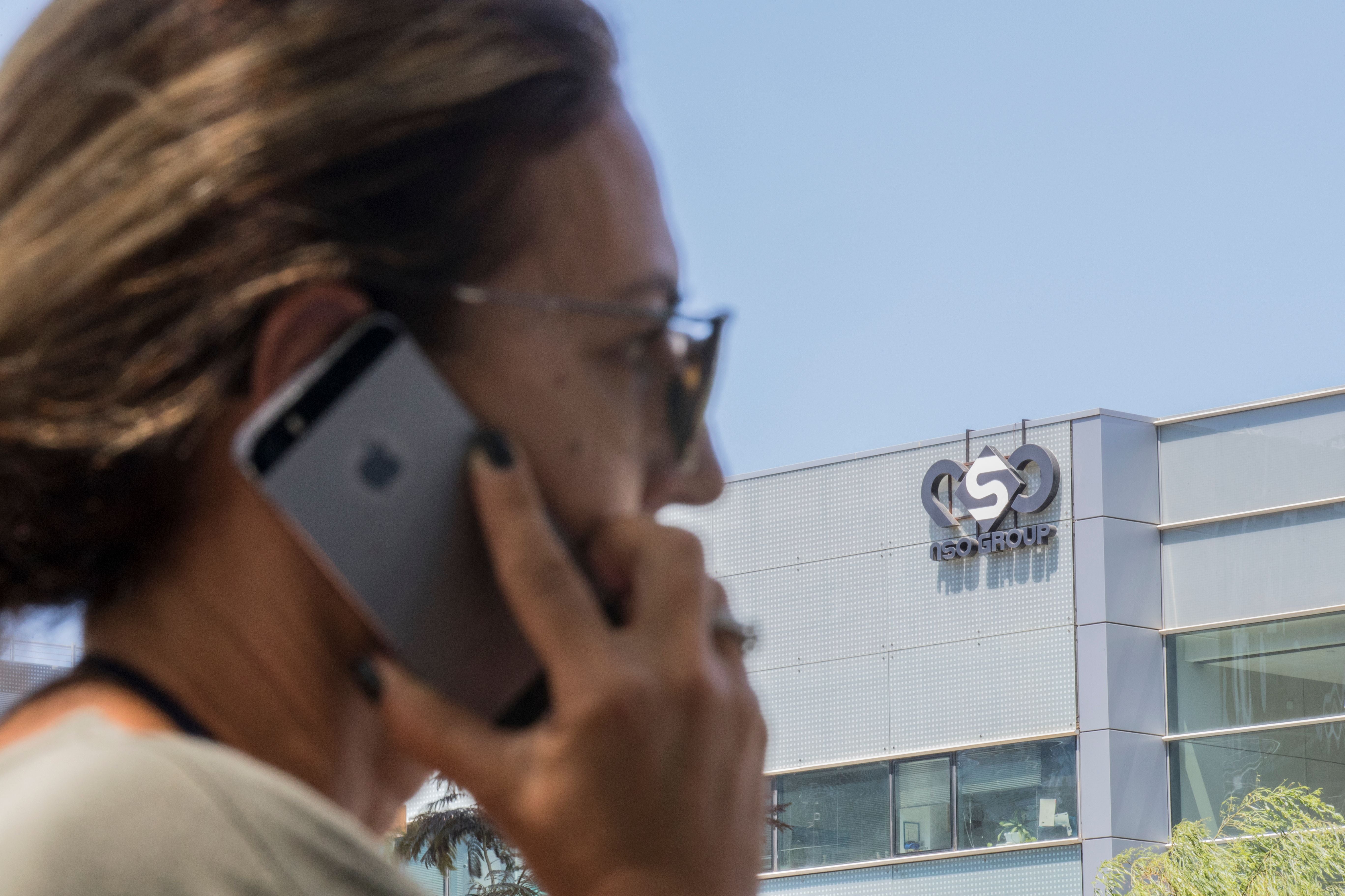 An Israeli woman uses her iPhone in front of the building housing the Israeli NSO group, on August 28, 2016