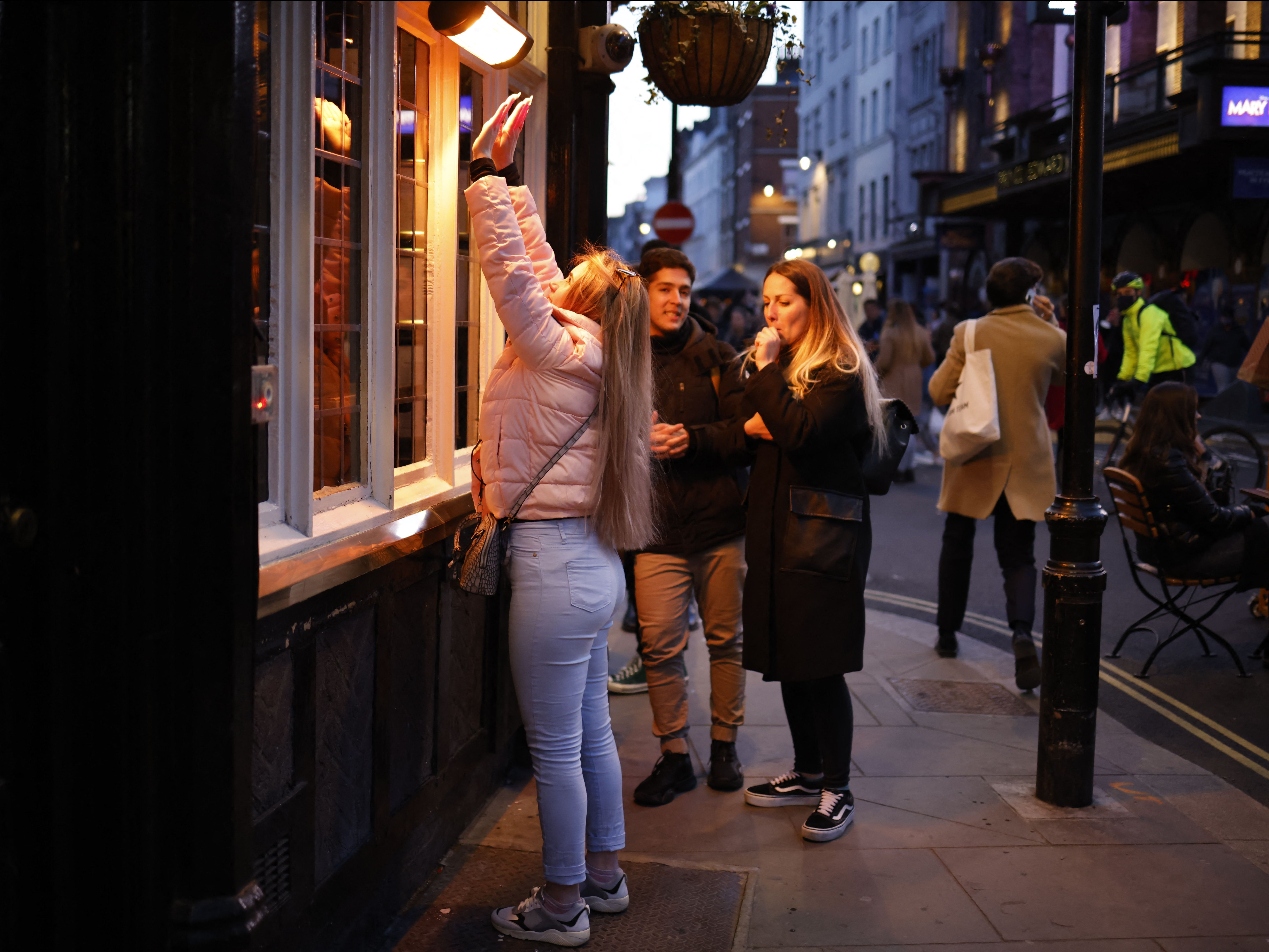 File image: A customer warms her hands on a pavement heater outside a pub