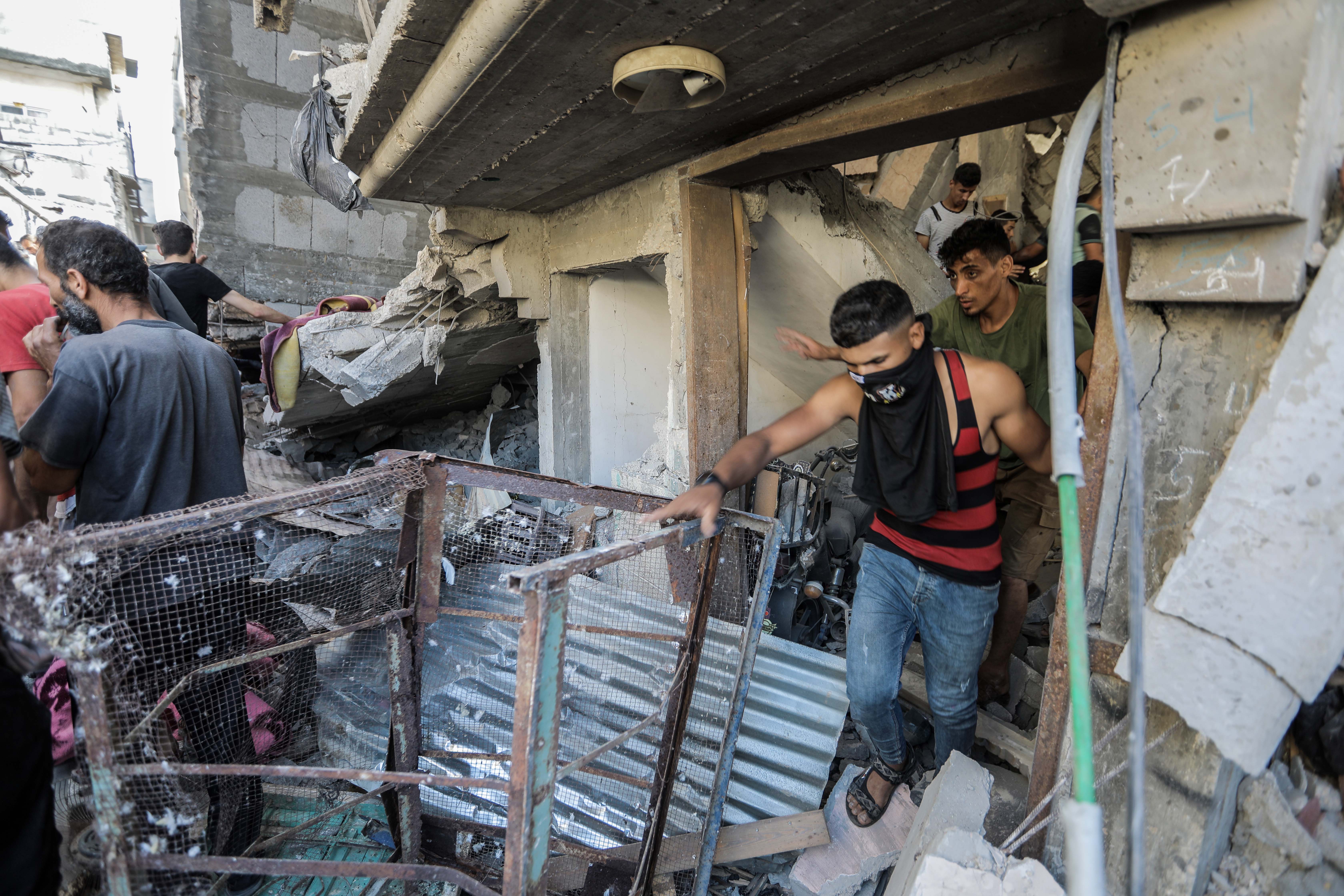 People search buildings destroyed during airstrikes on November 18, 2023 in Khan Yunis, Gaza. Heavy fighting rages in the northern Gaza Strip as Israel encircles the area, despite increasingly pressing calls for a ceasefire.