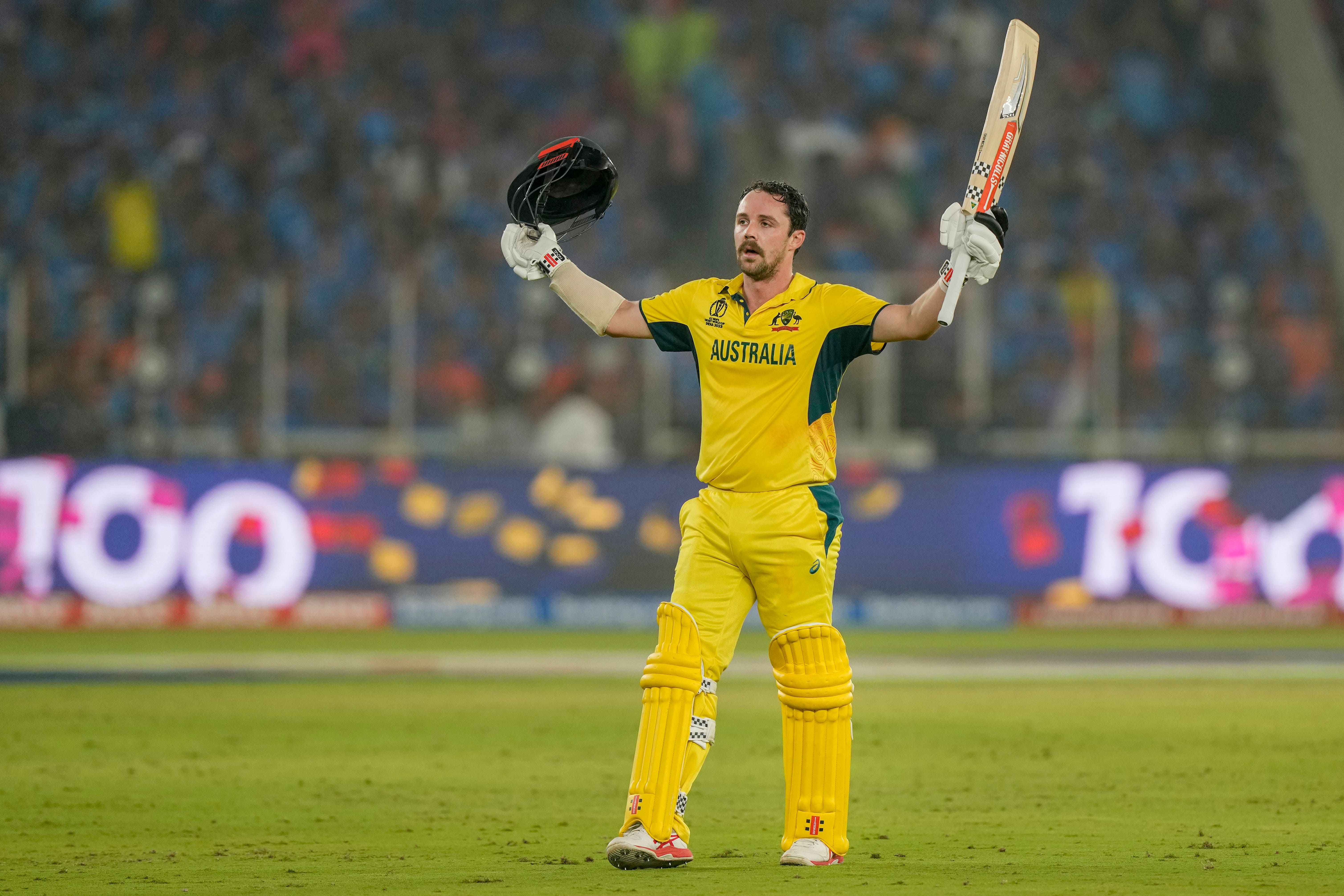 Travis Head raises his bat as he celebrates his century in the World Cup final