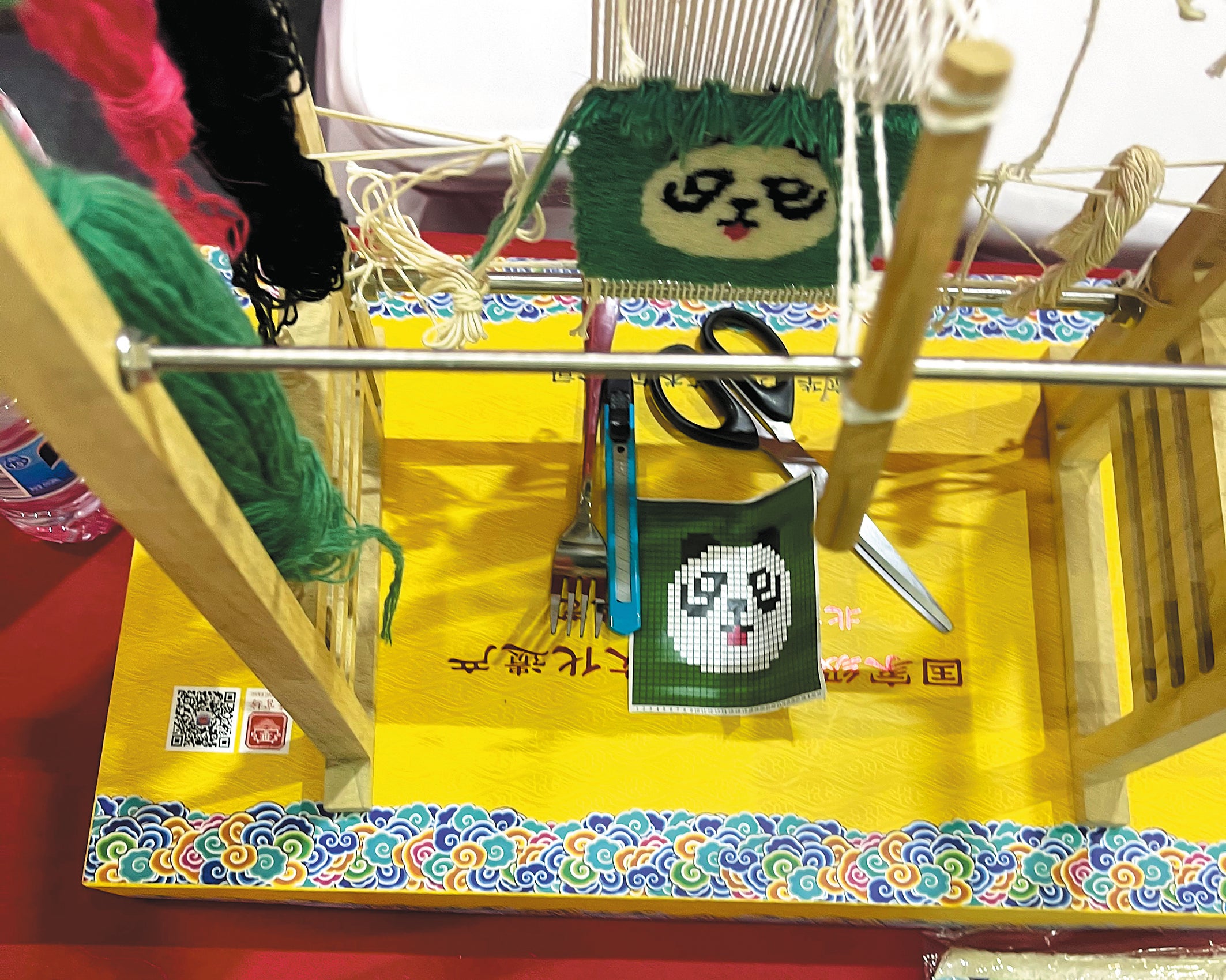 A miniature wooden loom shows the complexity and delicacy of imperial carpet-making at the Beijing International Week of Intangible Cultural Heritage in October 2023