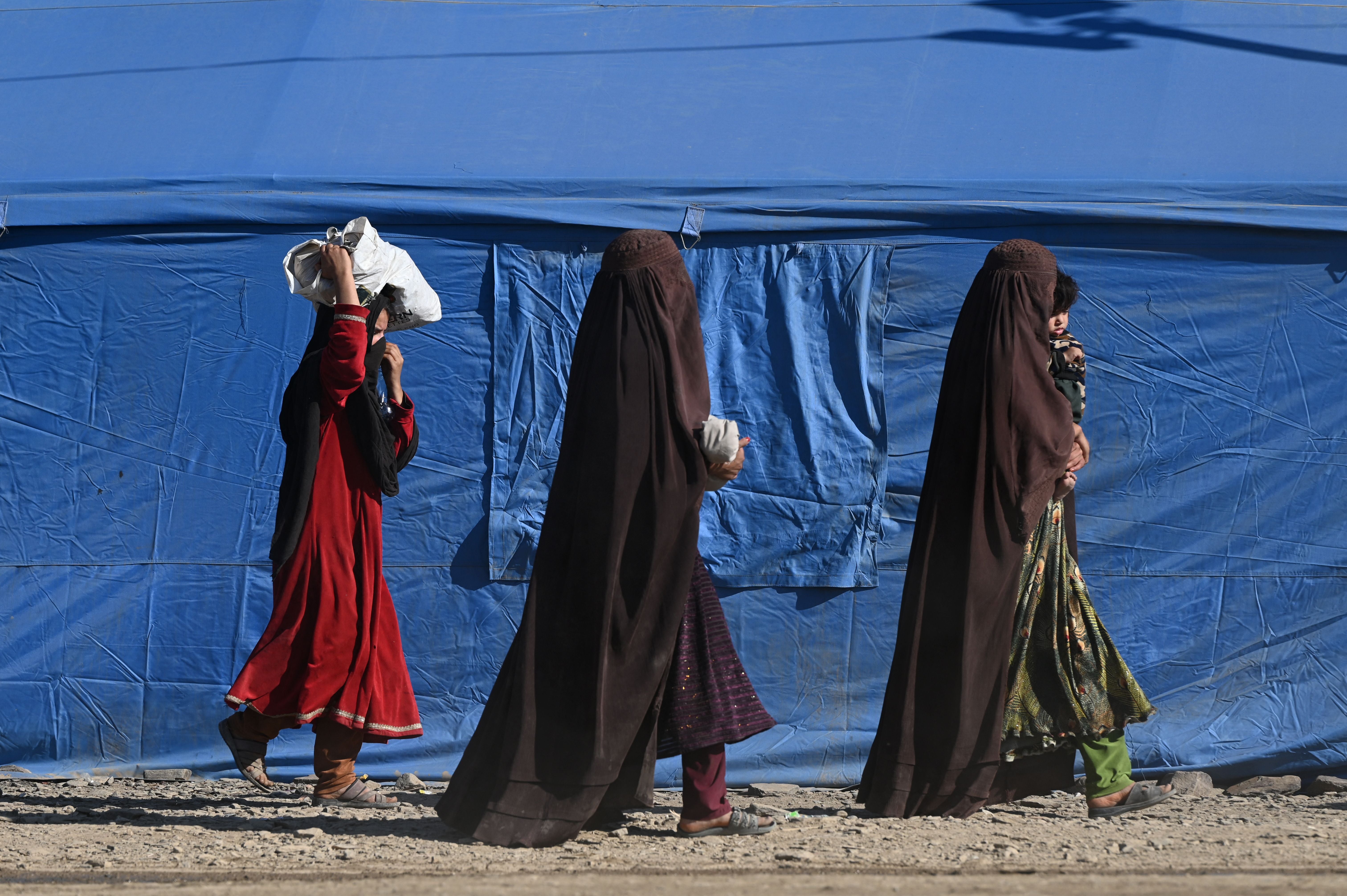 Afghan refugees walk through a makeshift camp upon their arrival from Pakistan, near the Afghanistan-Pakistan Torkham border in Nangarhar province