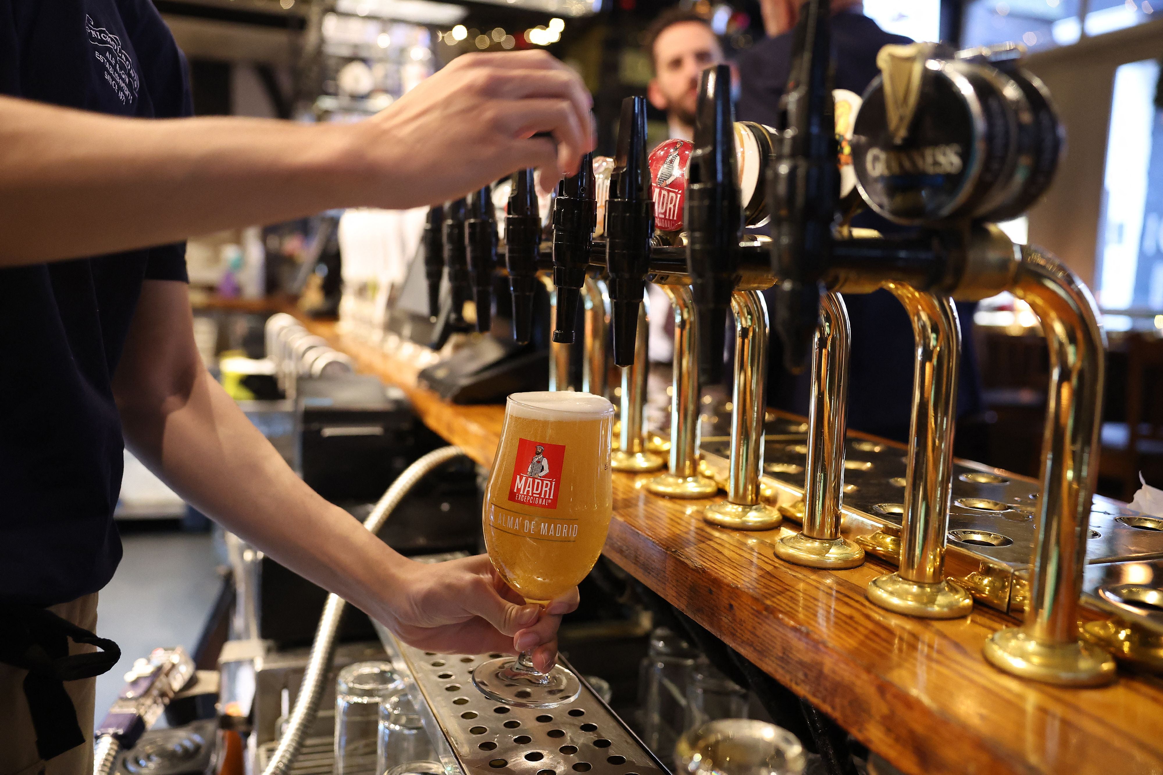 A bar worker pours a pint of lager at a pub in central London in November 2023