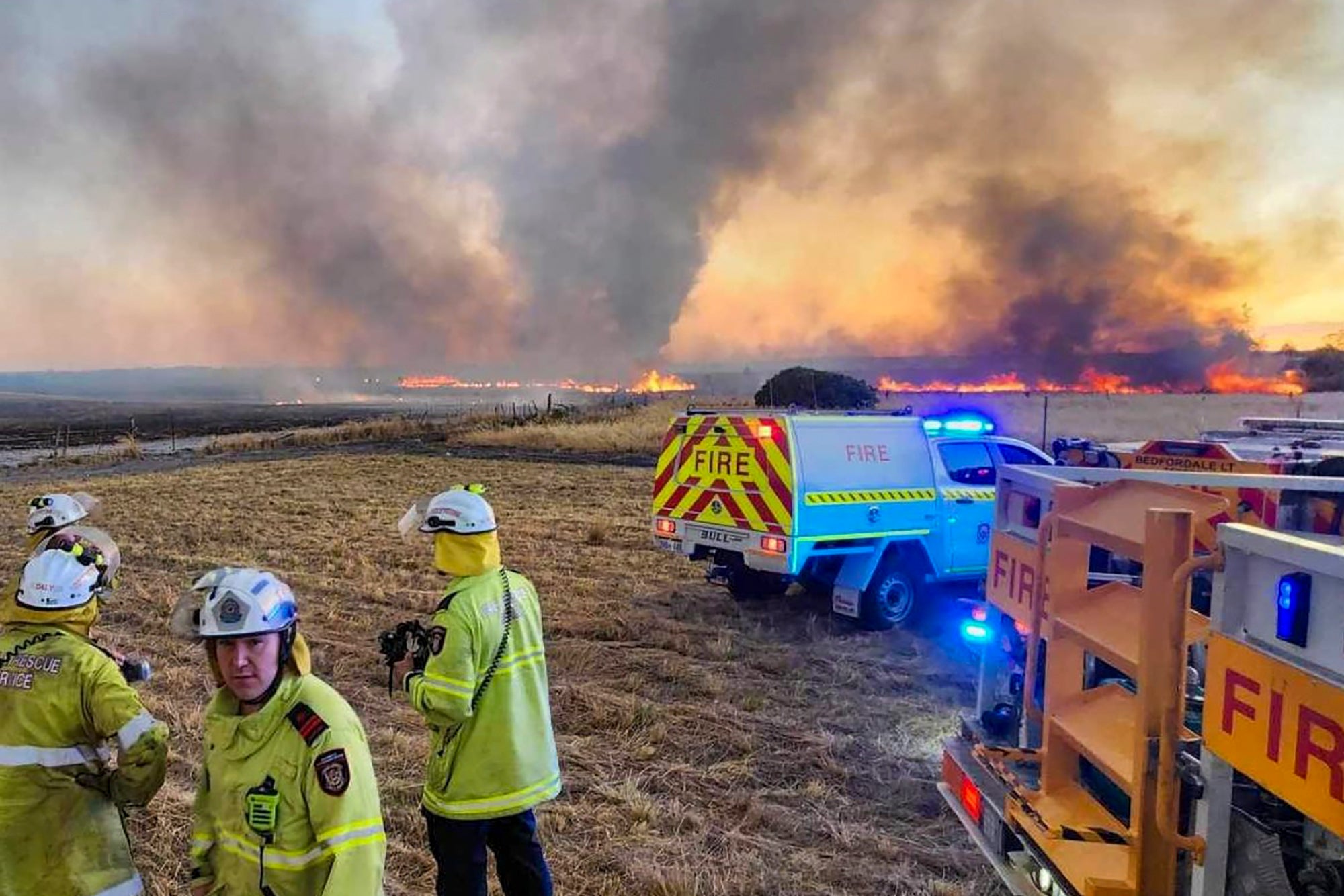 Australian firefighters watch as grassland burns near the city of Wanneroo, north of Perth, during a heatwave in 2023