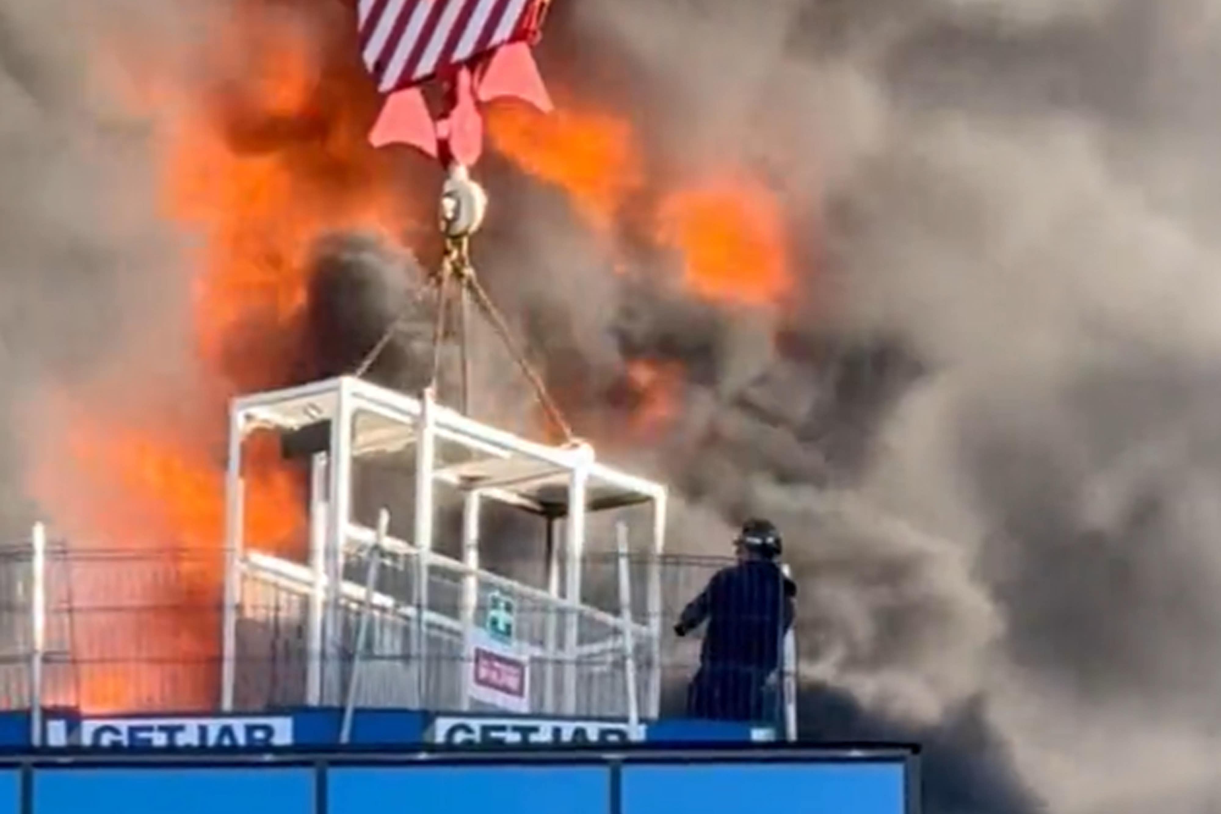 One video appeared to show a workman who was trapped on the roof being lifted to safety by a crane (Chris Lauder/X)