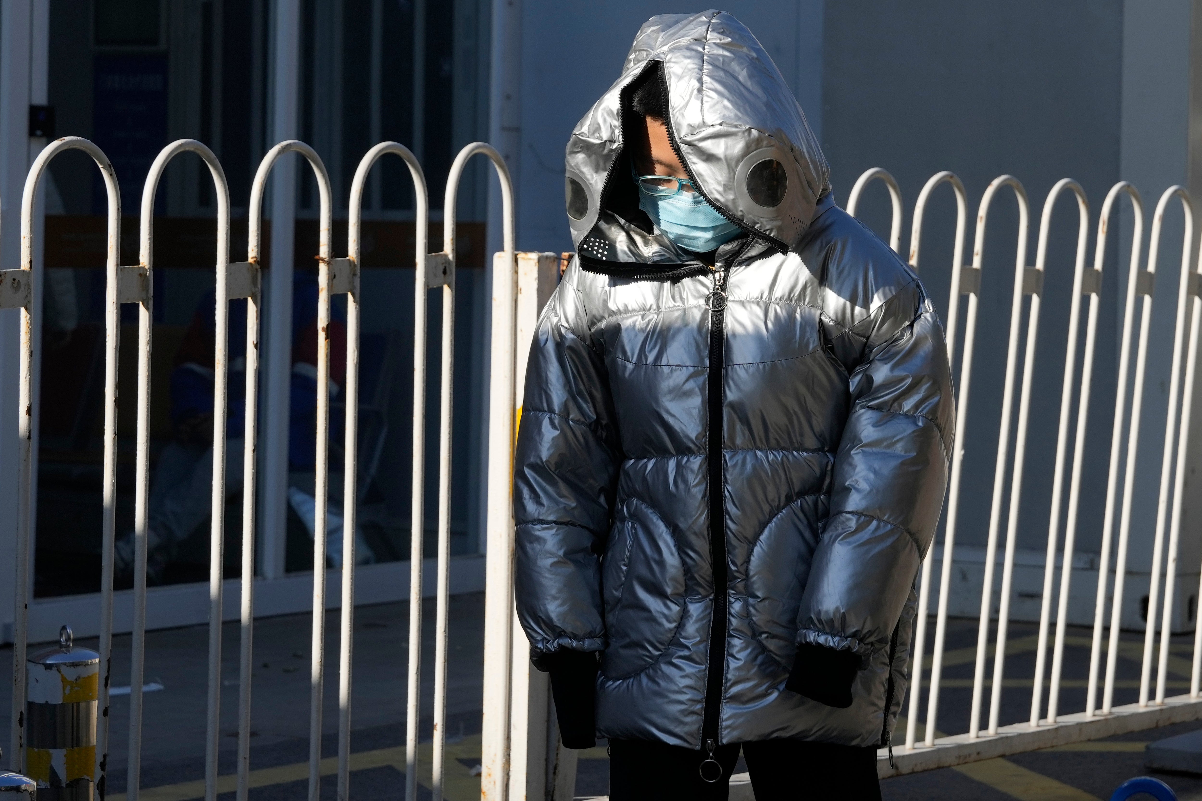 A child wearing a mask passes by a children’s hospital in Beijing