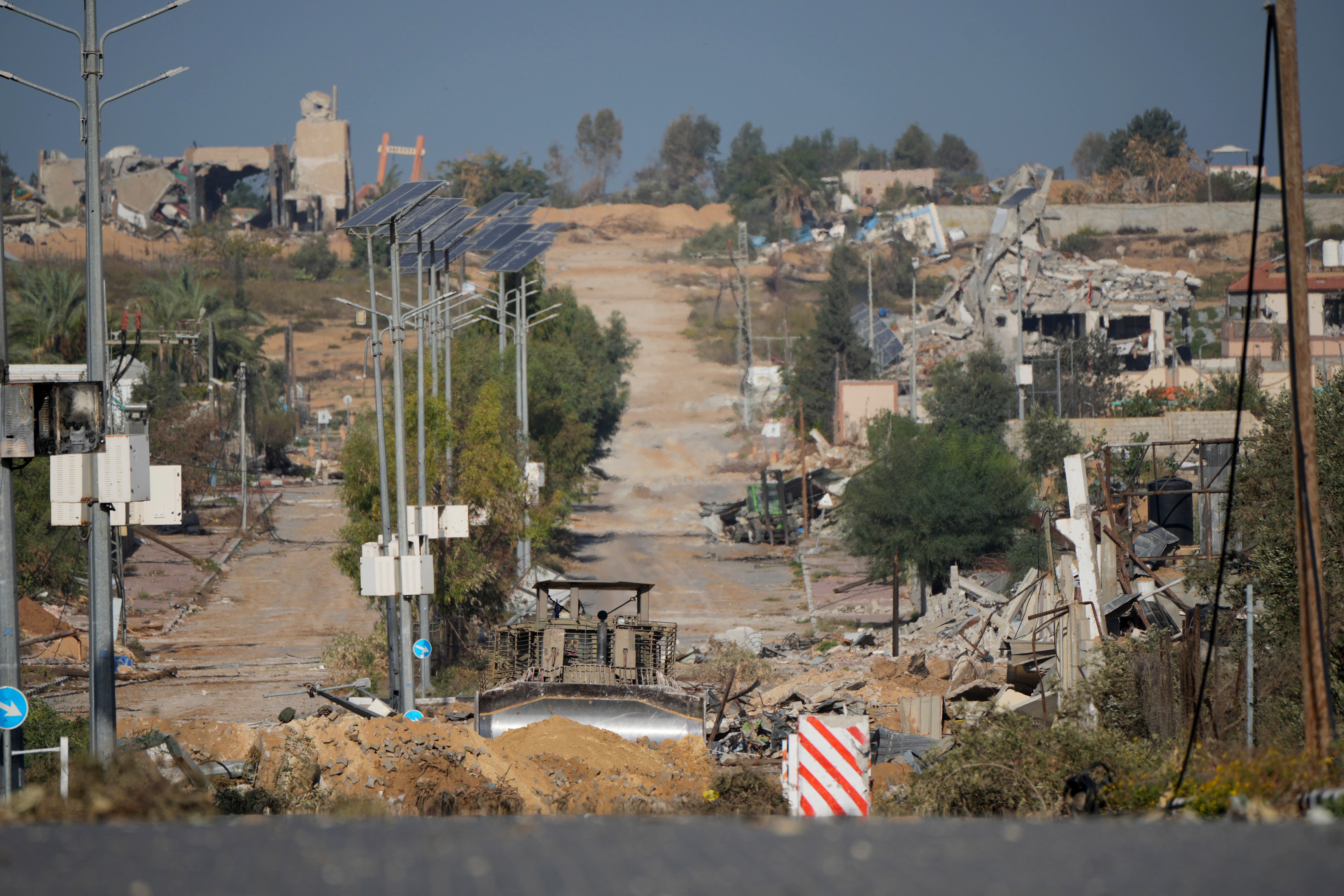 An Israeli bulldozer makes a roadblock at Salah al-Din road in central Gaza Strip as the temporary ceasefire went into effect (Hatem Moussa/AP)