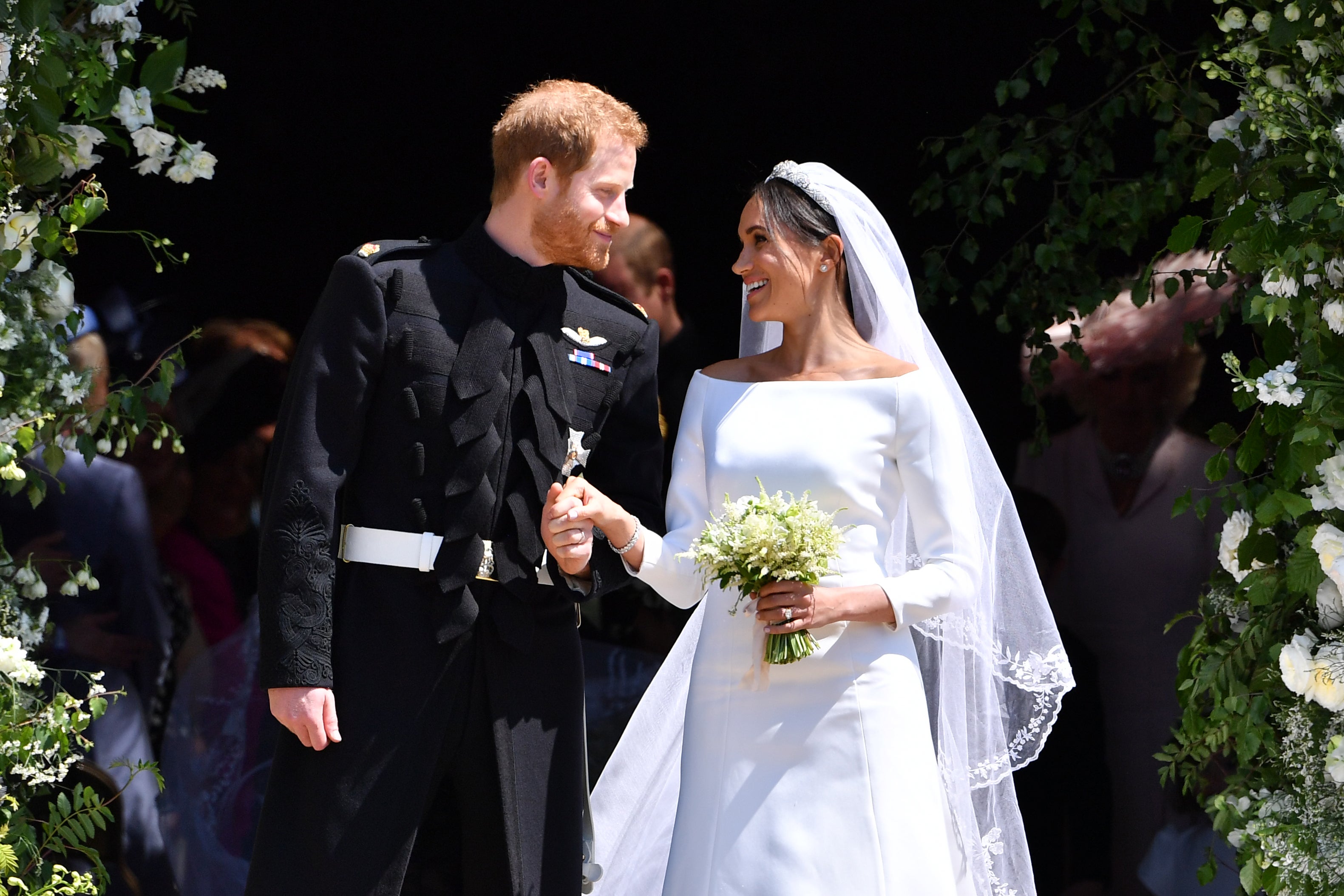 Britain's Prince Harry, Duke of Sussex and his wife Meghan, Duchess of Sussex leave from the West Door of St George's Chapel, Windsor Castle, in Windsor on May 19, 2018 in Windsor, England.