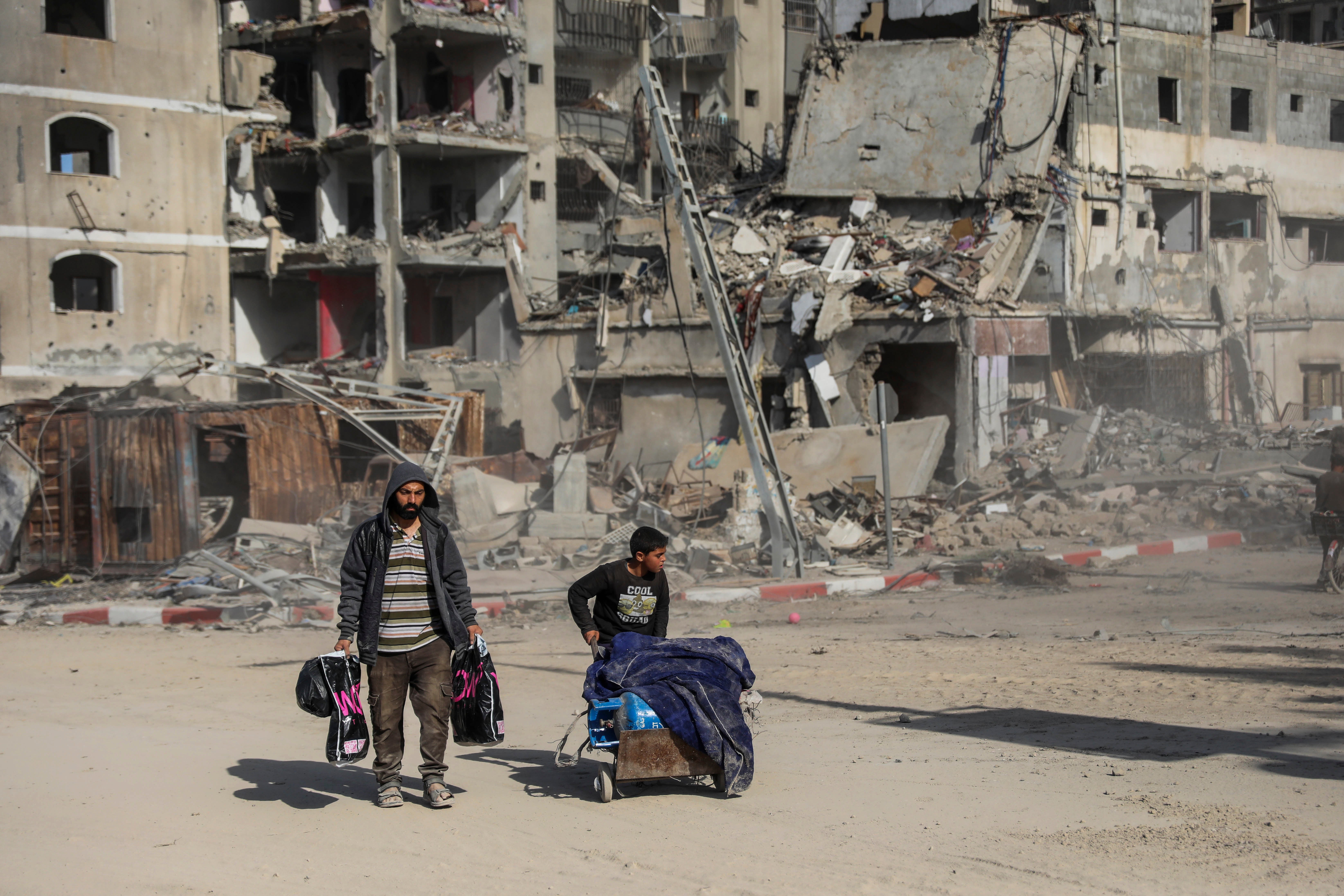 Palestinians walk through destruction in Gaza City