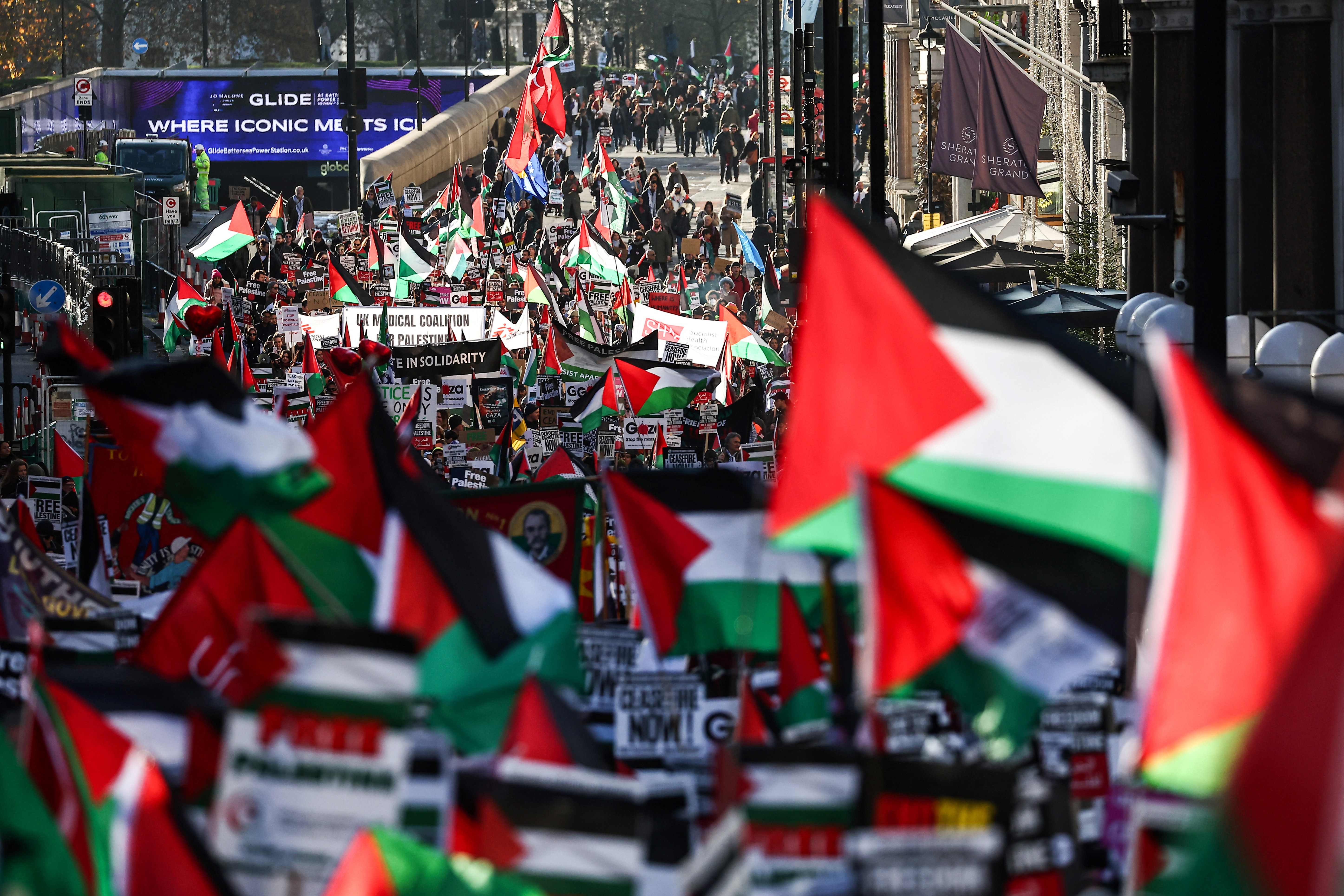 Protesters holding placards and Palestinian flags take part in a ‘National March For Palestine’ in central London on Saturday