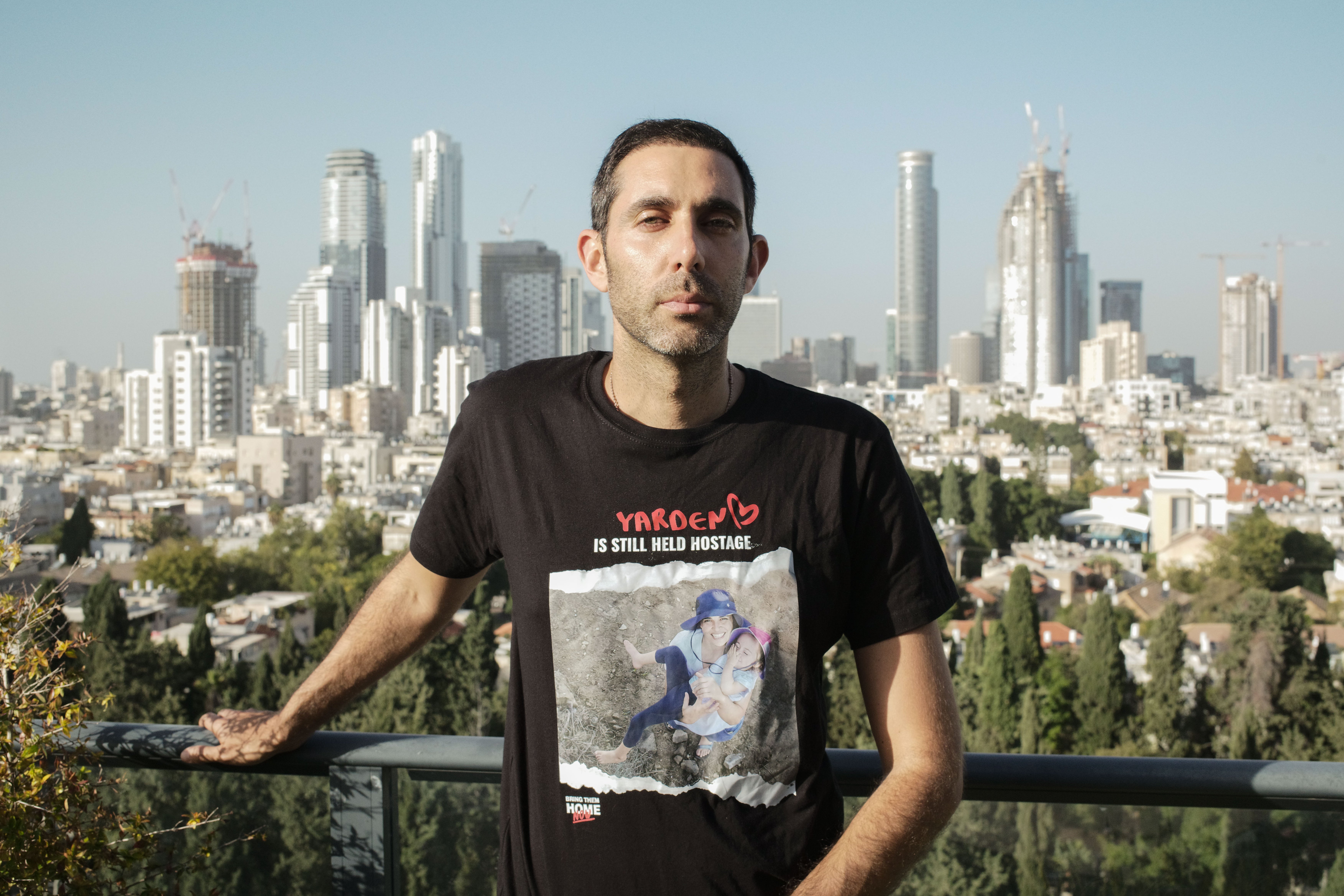 Gili Roman, brother of Yarden Roman-Gat, stands on the balcony of his family’s apartment in Tel Aviv