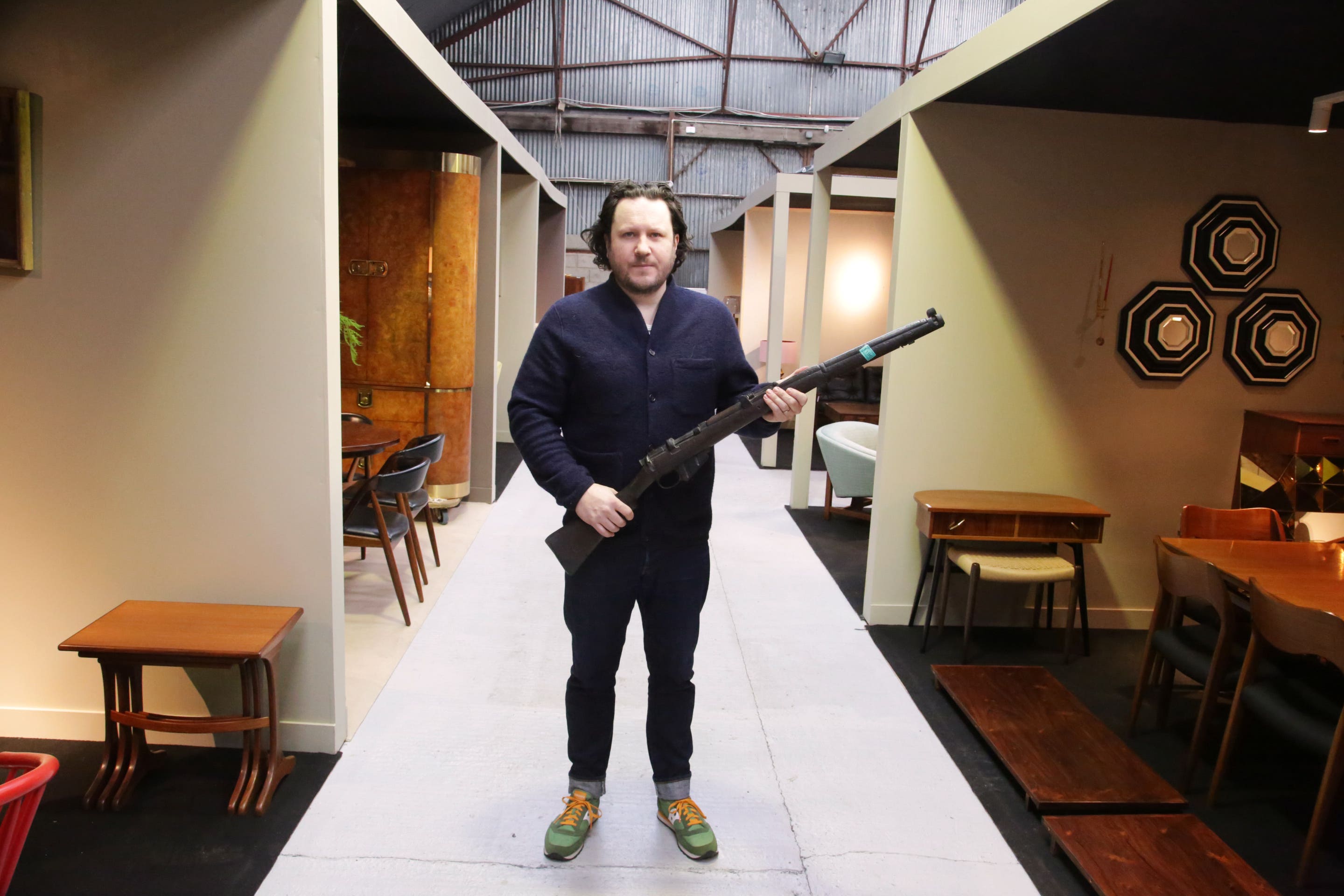 Killian McNulty of Historic Interiors with a prop rifle used in the 1996 film Michael Collins (Niall Mullen/PA)