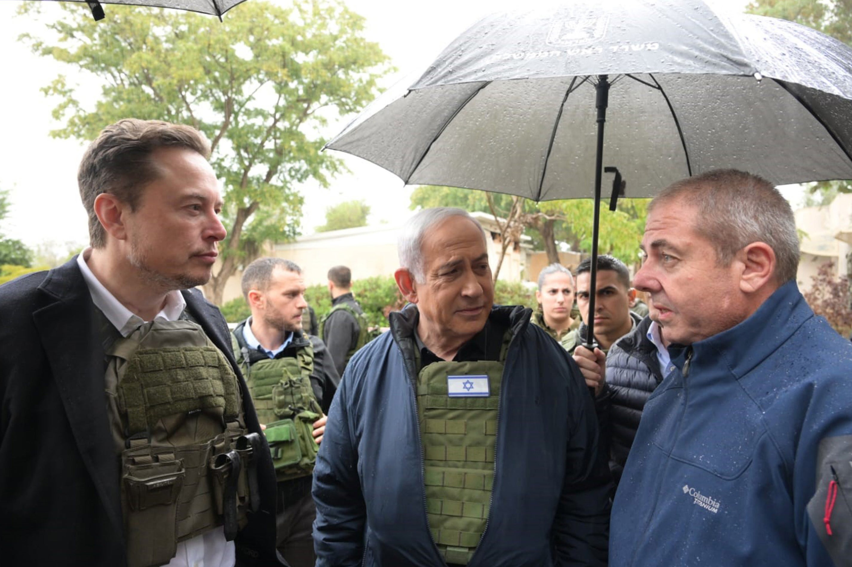 Israel's Prime Minister Benjamin Netanyahu (centre) takes Elon Musk (left) on a tour of Kibbutz Kfar Aza