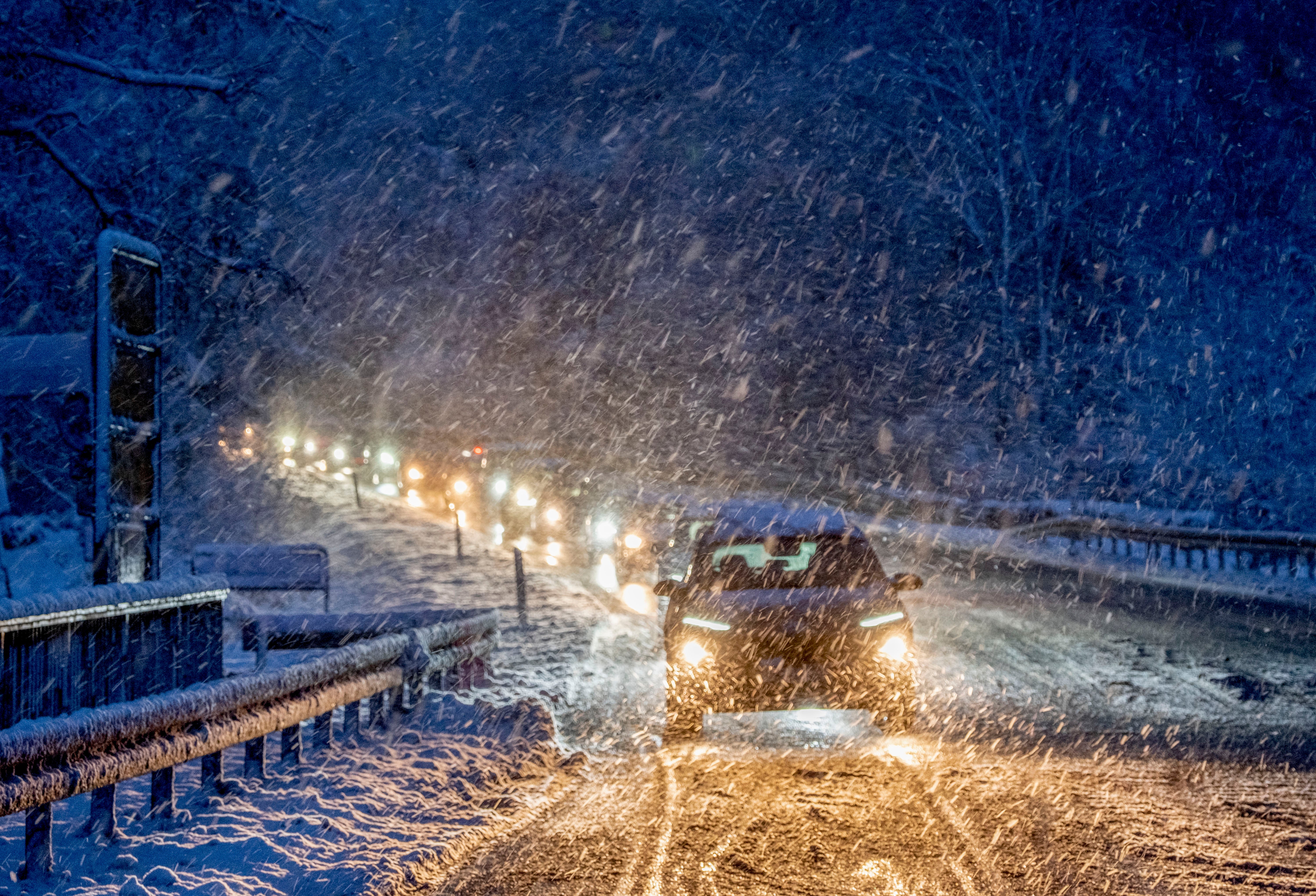 Commuters queue in heavy snowfalls on a country road in a forest of the Taunus region near Frankfurt, Germany, early Tuesday, Nov 28