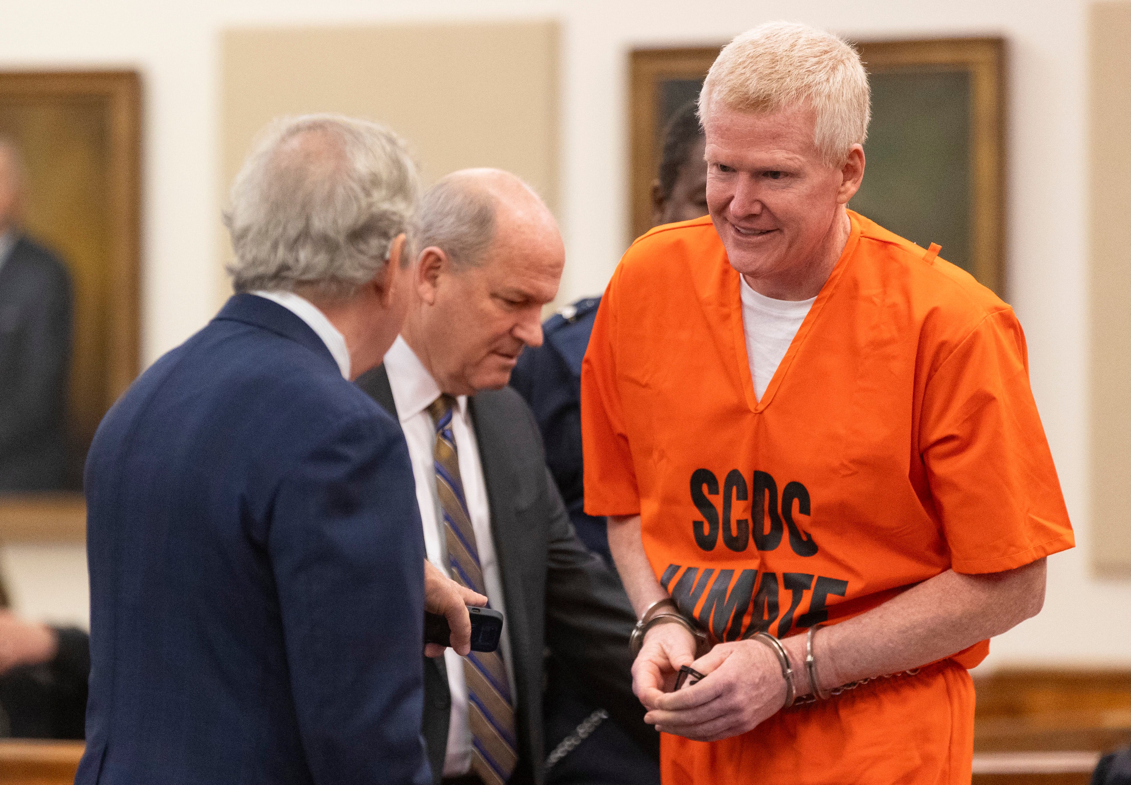 Alex Murdaugh talks with his attorneys Dick Harpootlian, left, and Jim Griffin during his sentencing