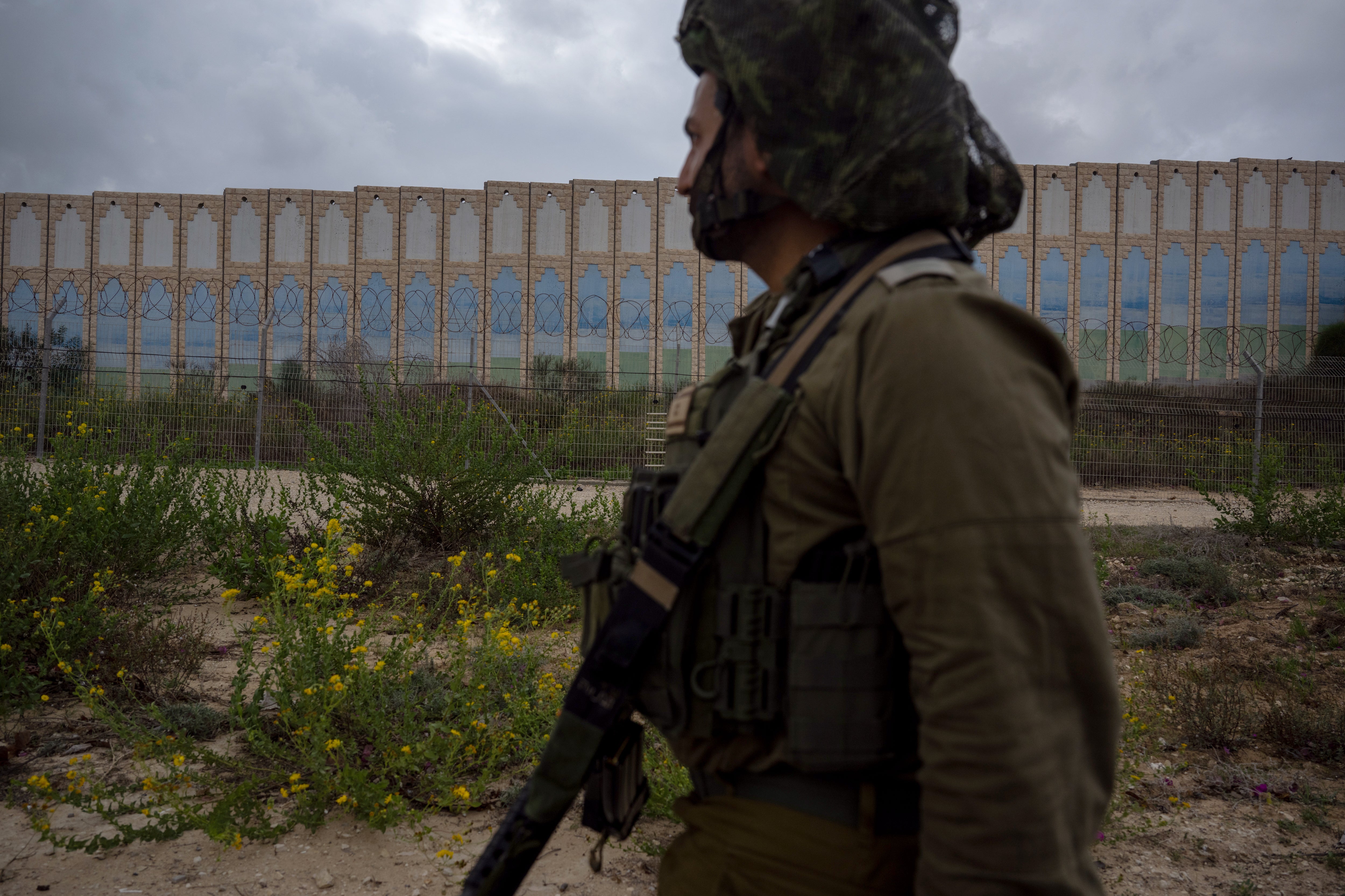 An IDF officer walks past the protective barriers near the border fence with the Gaza Strip on November 19, 2023 in Netiv HaAsara, Israel