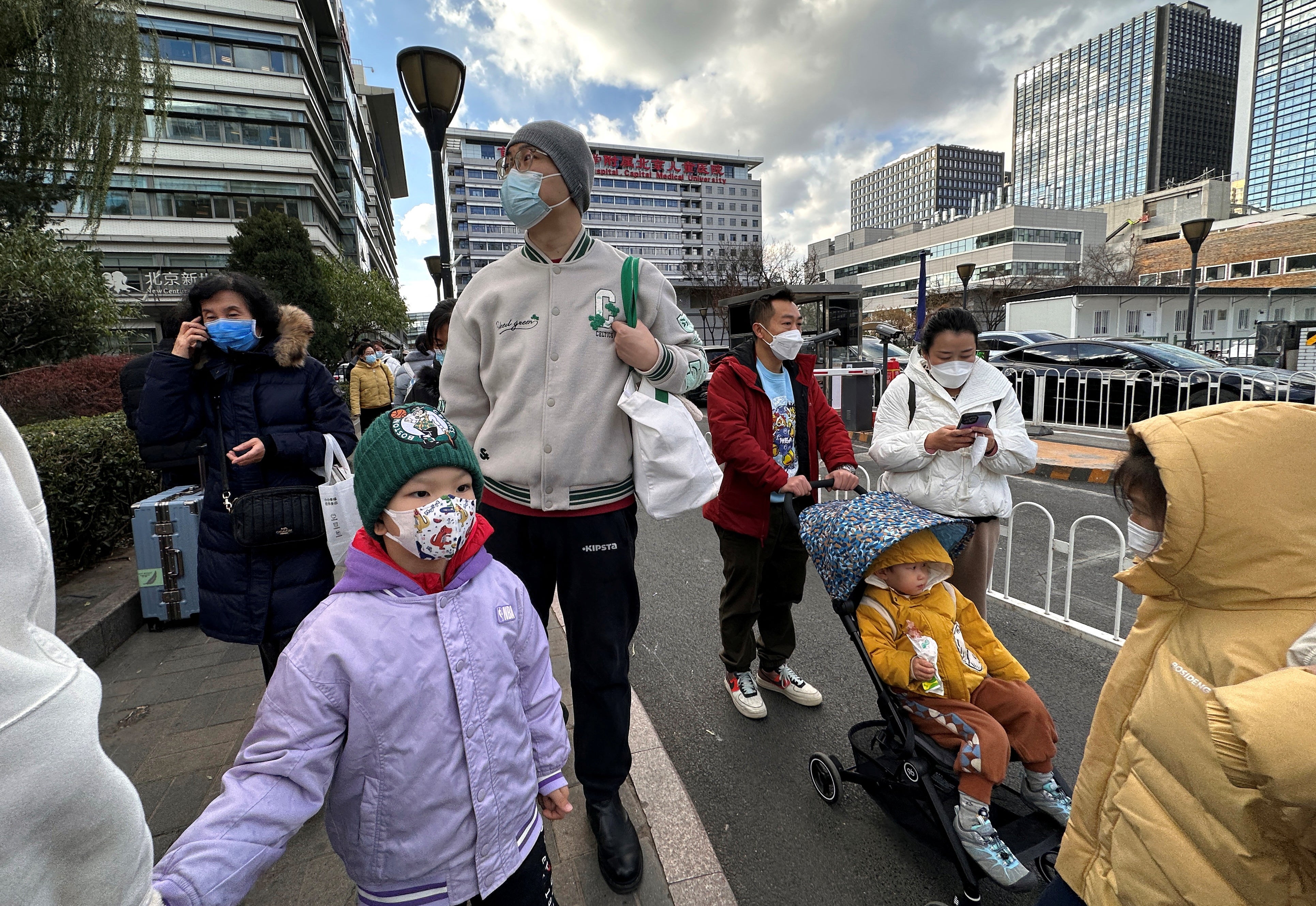 People and children leave a children’s hospital in Beijing, China