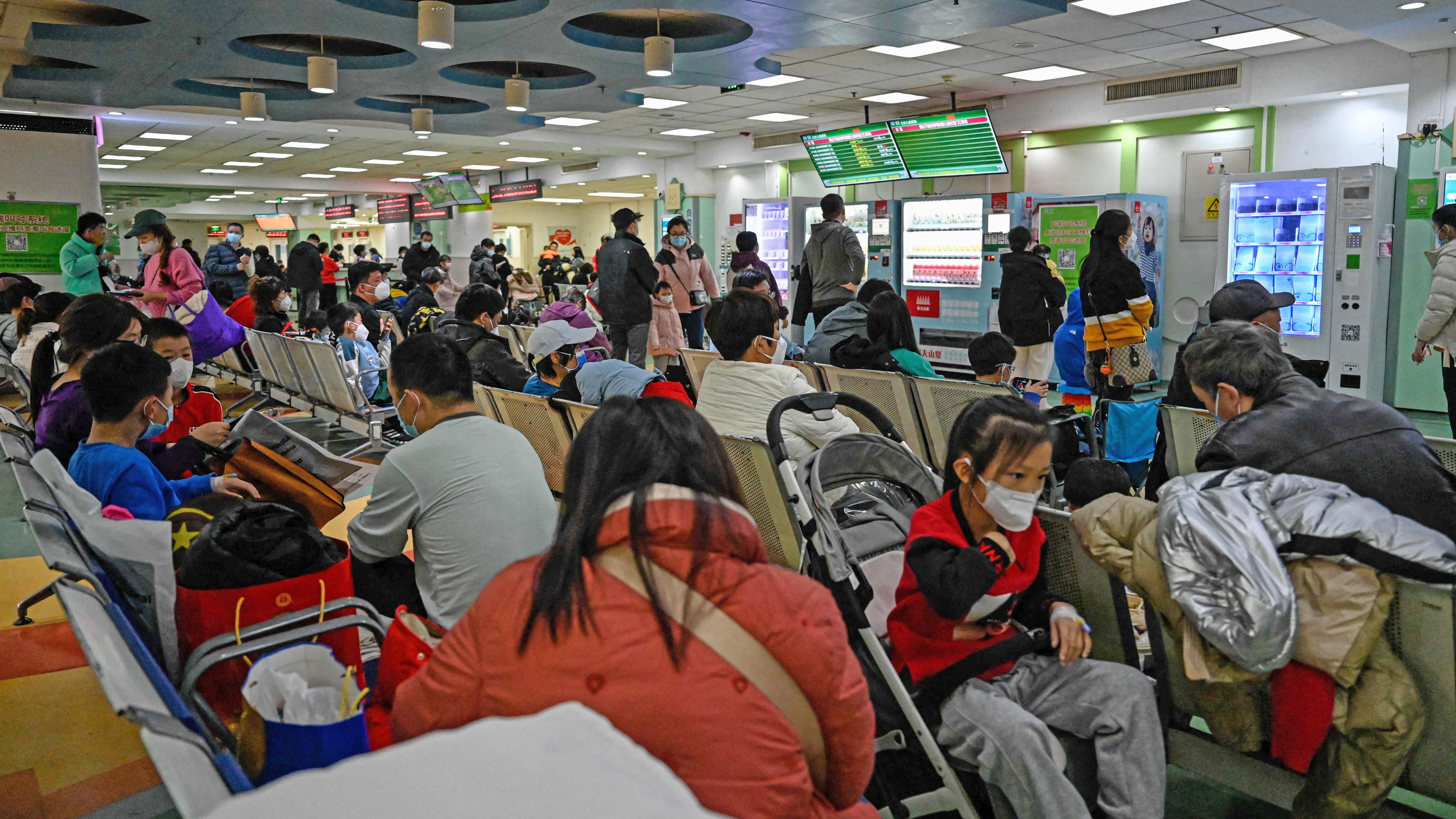 Children and their parents wait at an outpatient area at a children hospital in Beijing