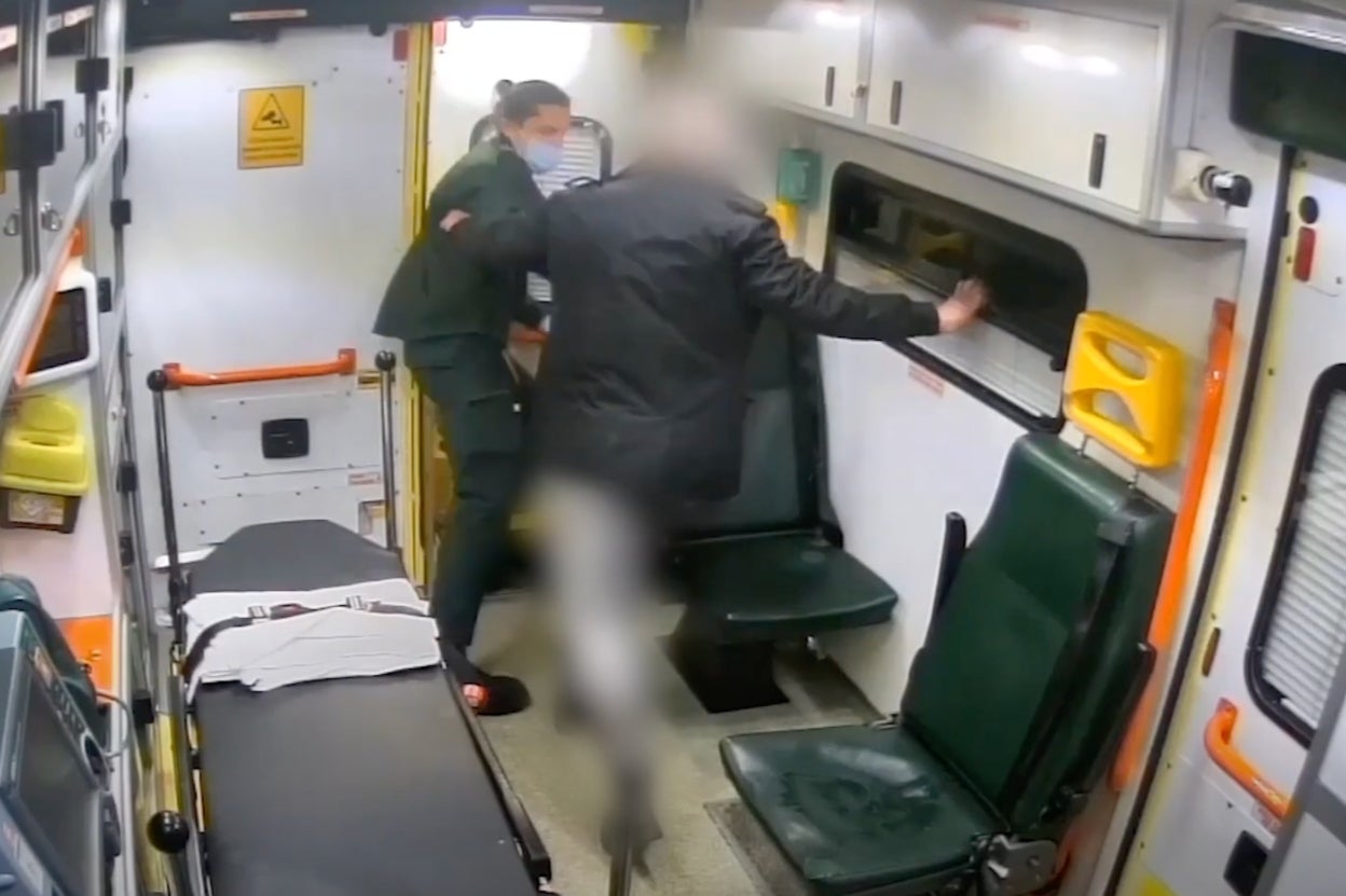 The medic is shoved out the back door of the ambulance