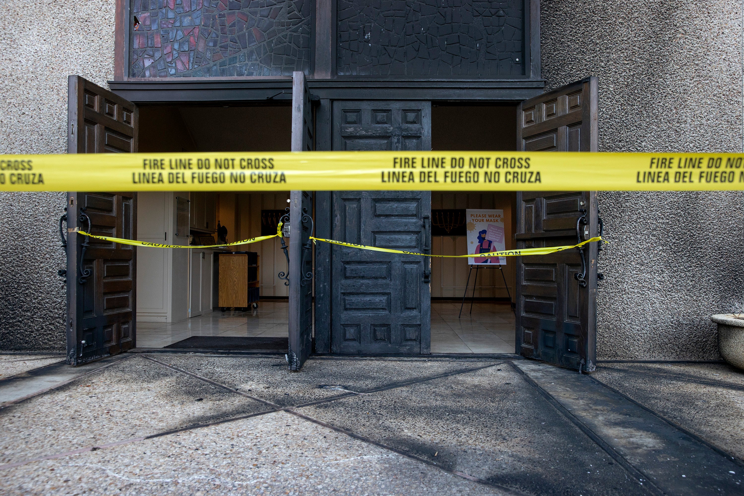 Caution tape marks the front doors at Congregation Beth Israel on 1 November 2021, after fire at the synagogue in Austin, Texas, the previous day.