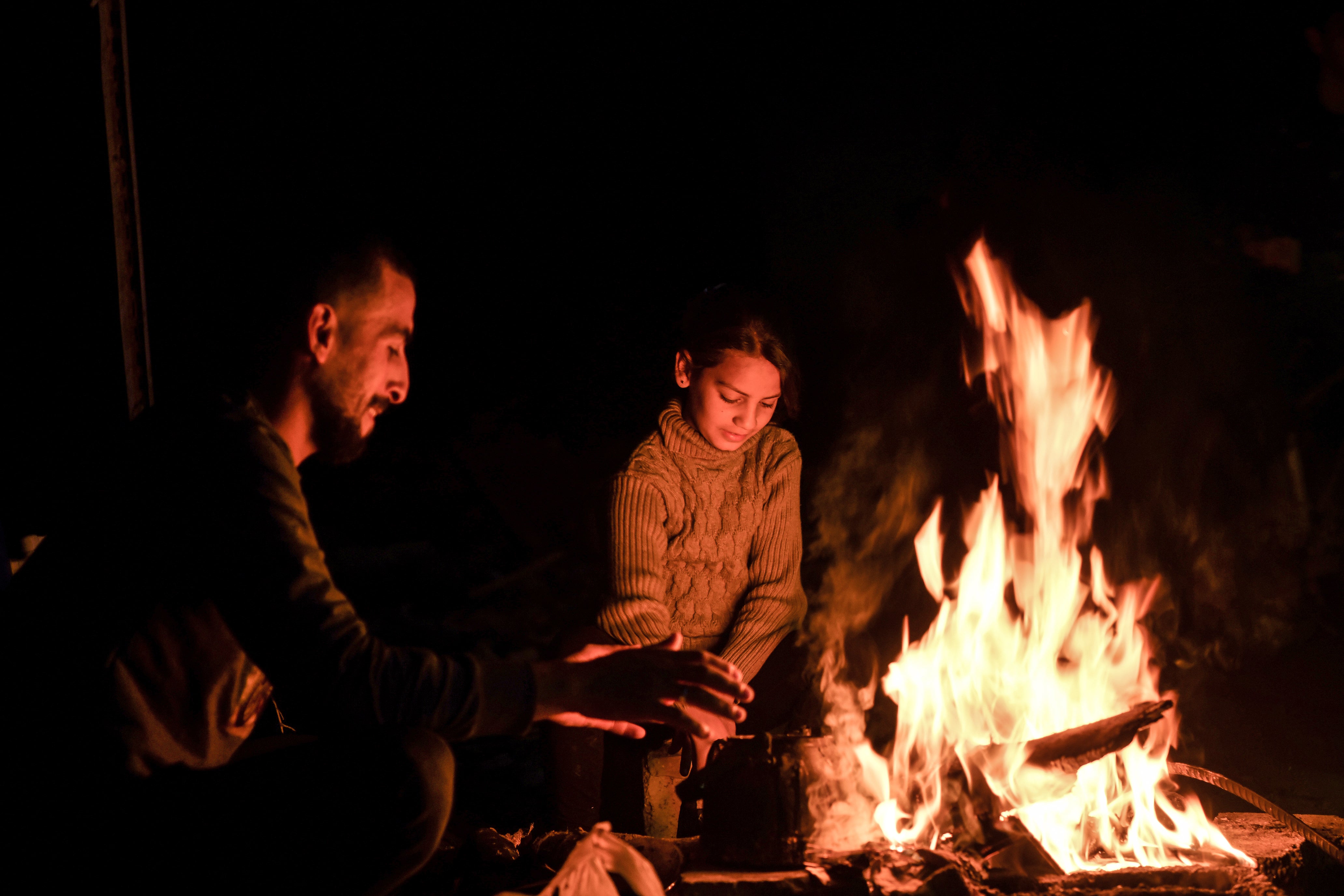 Families cook using wood and fire as they struggle to live among the rubble