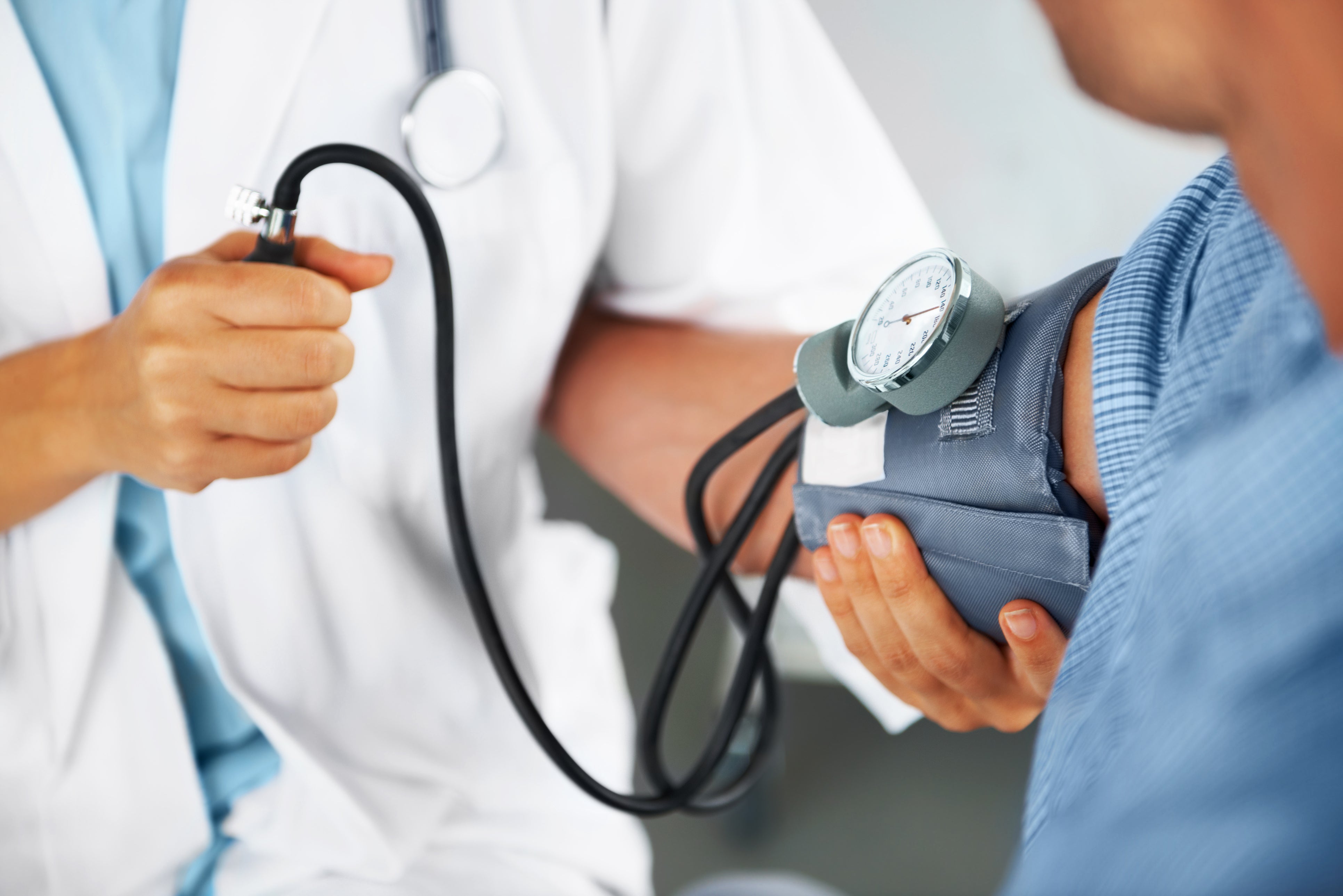 A doctor checks a patient’s blood pressure