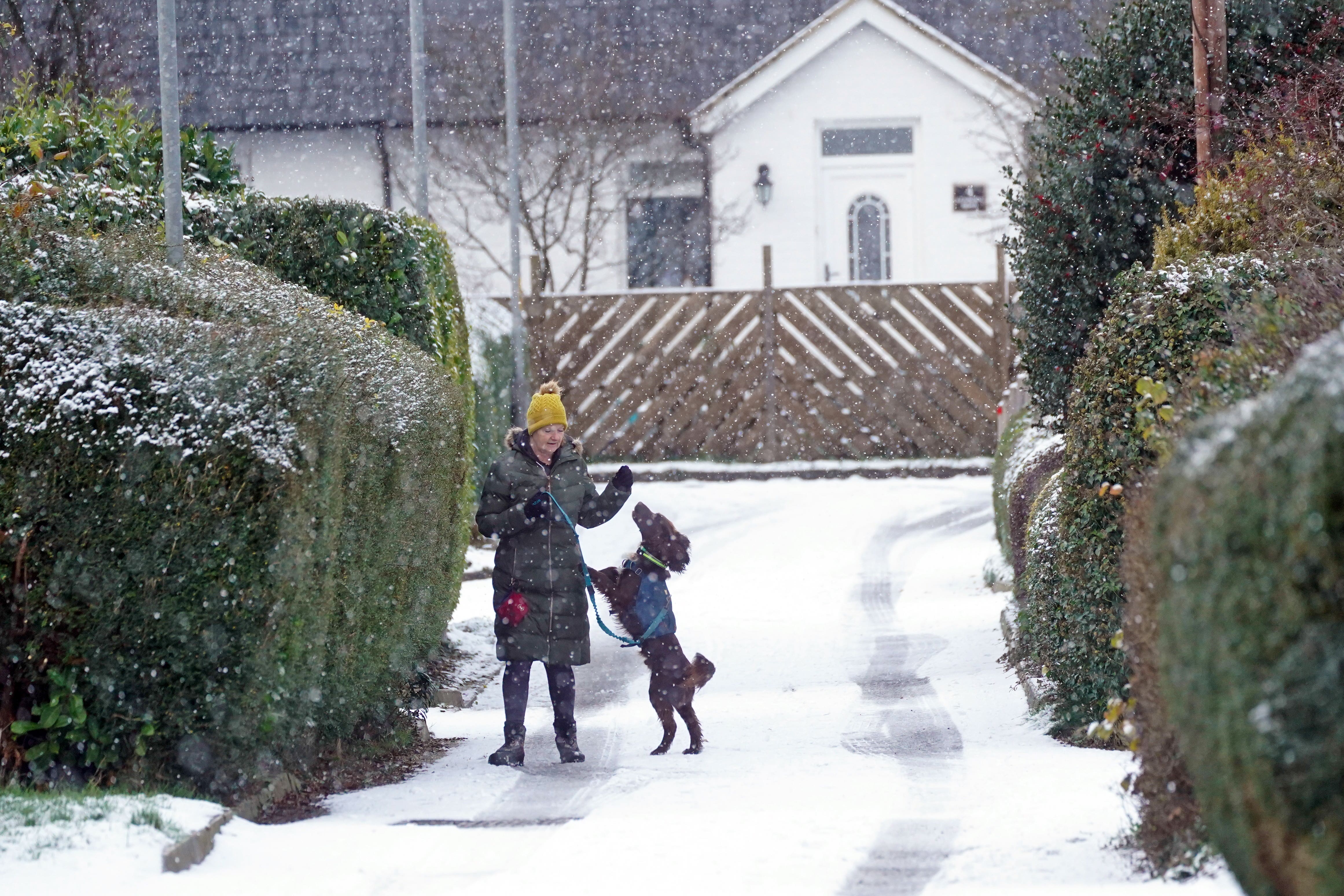 A woman with her dog in snow in Swarland, Northumberland (Owen Humphreys/PA)