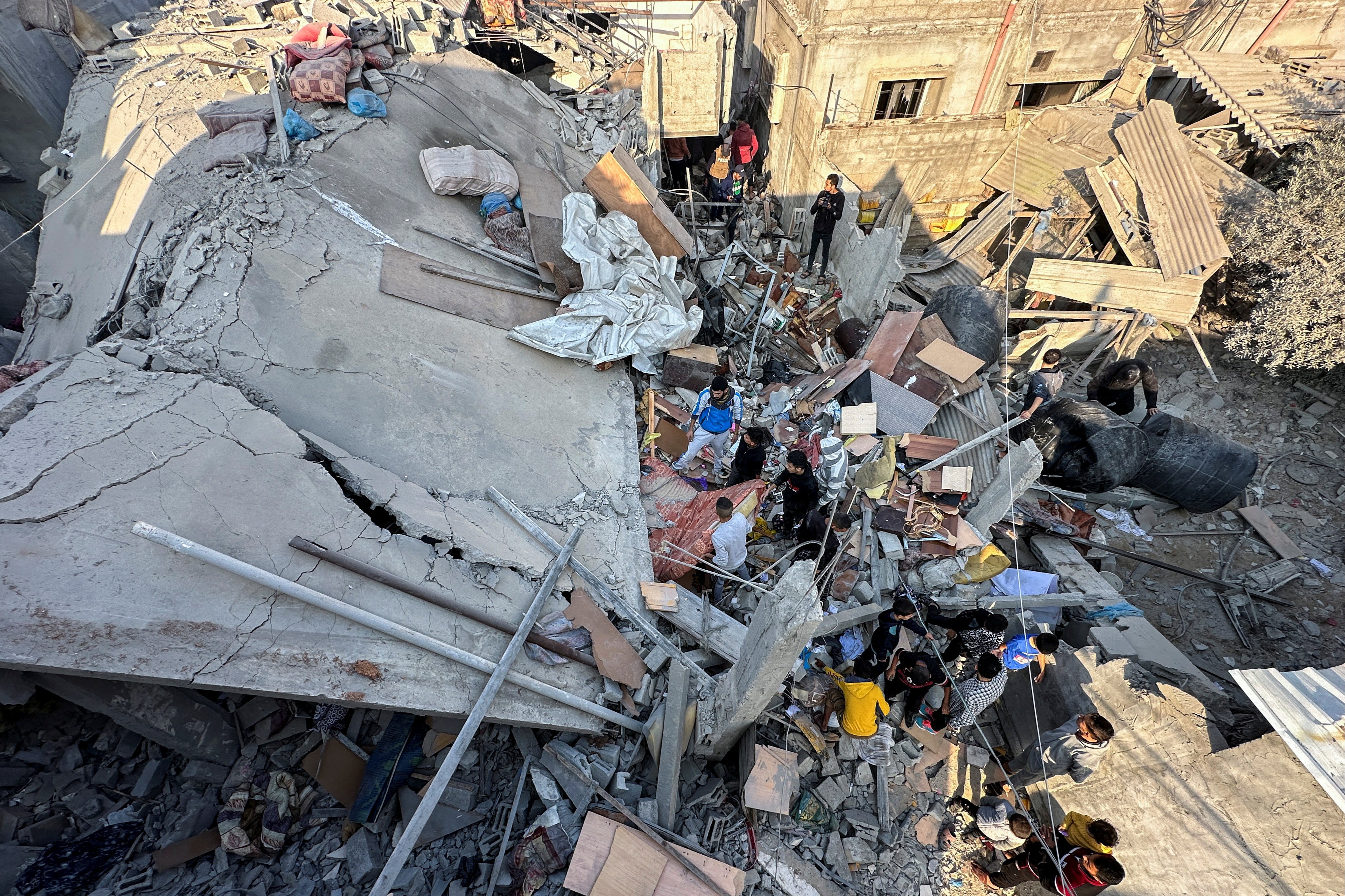 Palestinians inspect a house destroyed in an Israeli strike after a temporary truce between Hamas and Israel expired