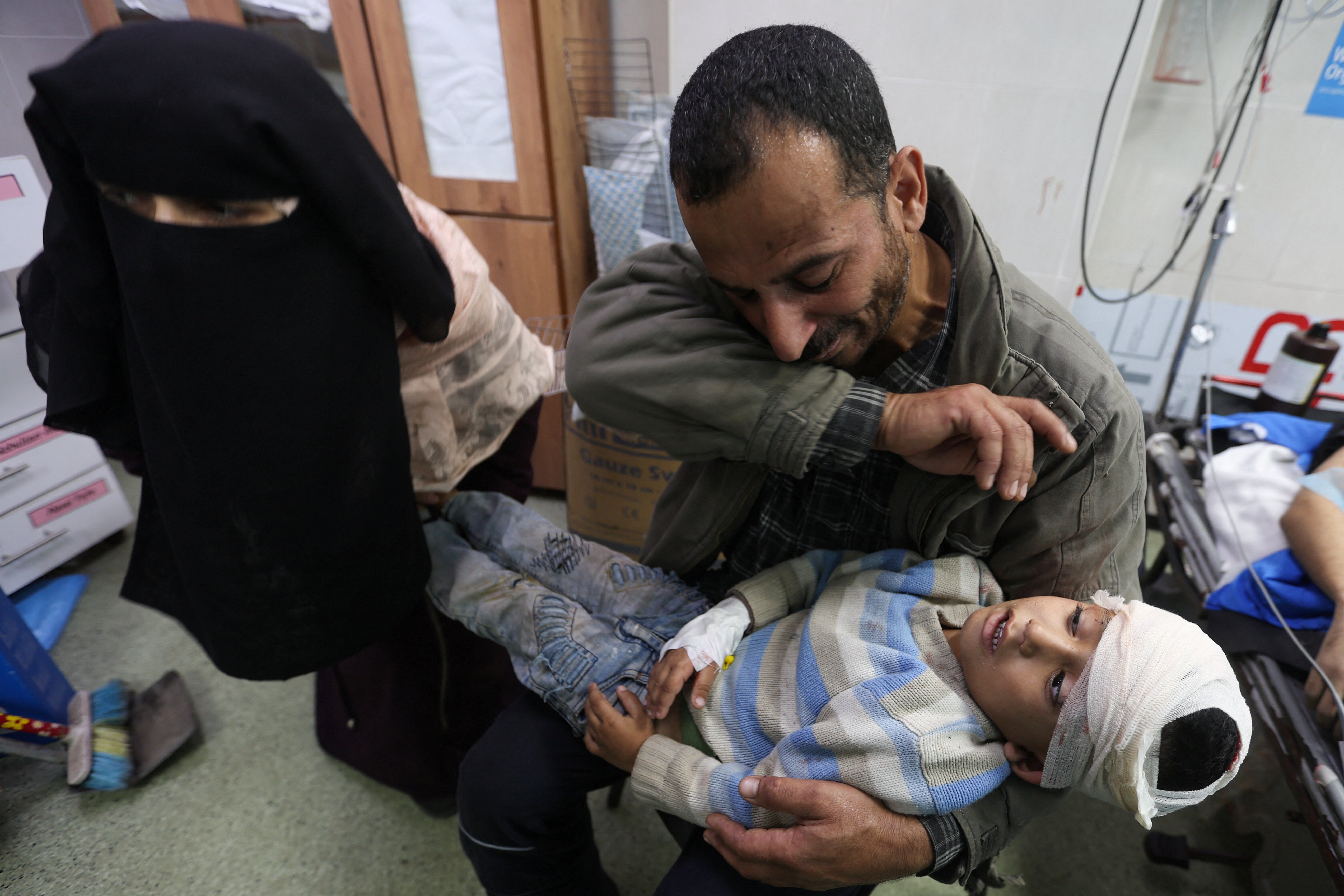 A Palestinian boy wounded in an Israeli strike is carried to Nasser Hospital in western Khan Younis this morning