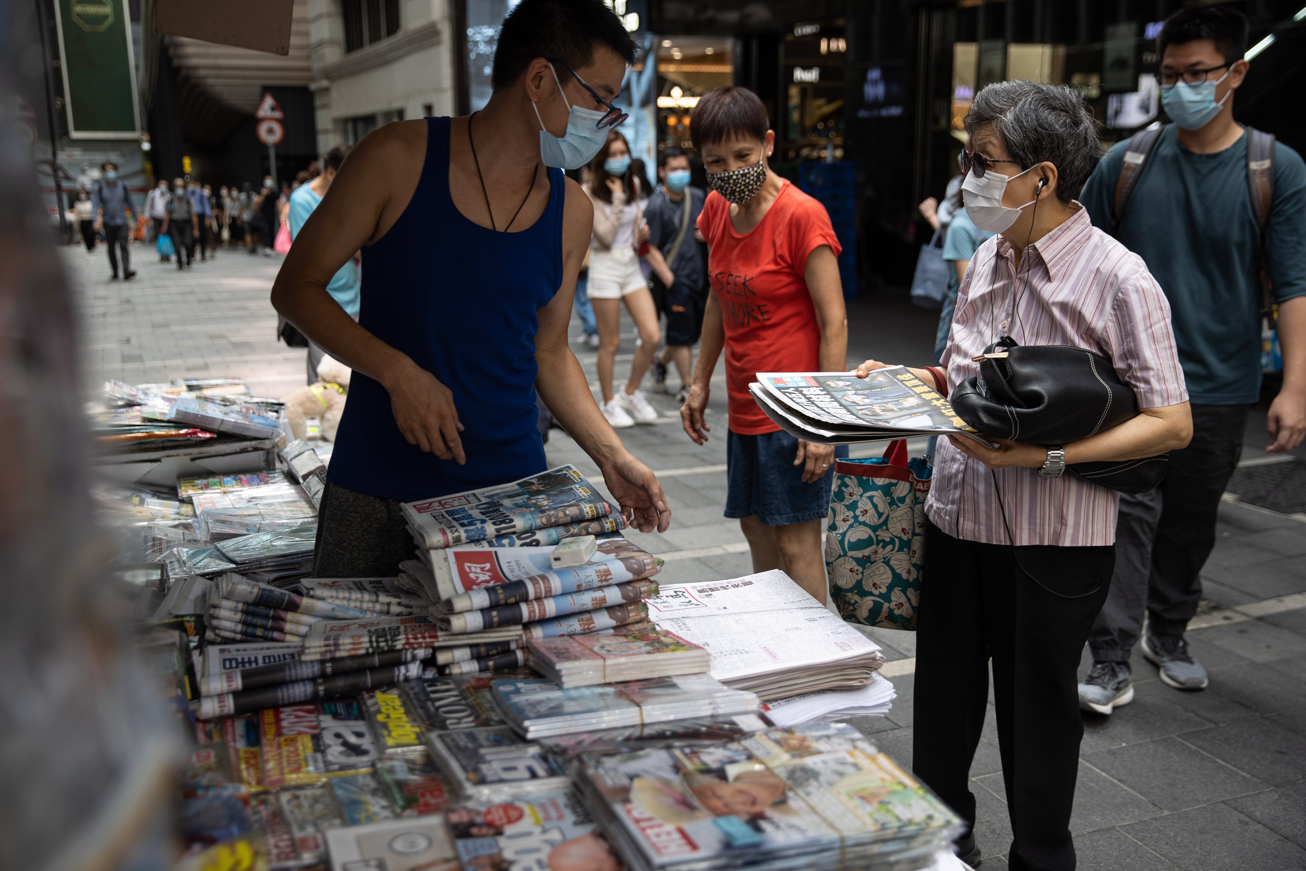 File: A woman buys newspaper at a news stand in Hong Kong, China