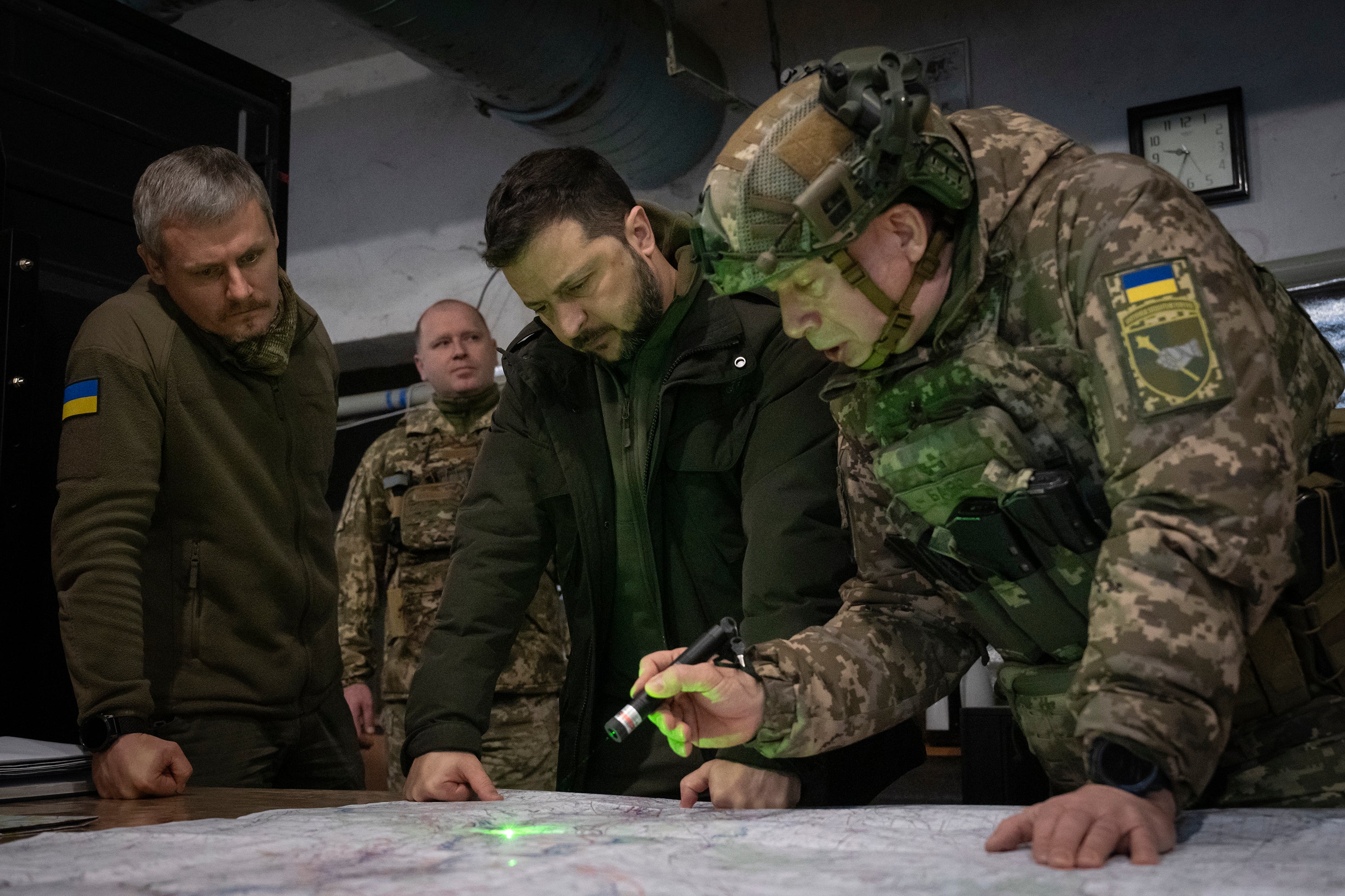 Ukrainian President Volodymyr Zelensky, Commander of Ukraine's Ground Forces Col.-Gen. Oleksandr Syrsky, right, and Roman Mashovets, deputy head of the Presidential Office, look at a map during their visit to the front-line city of Kupiansk